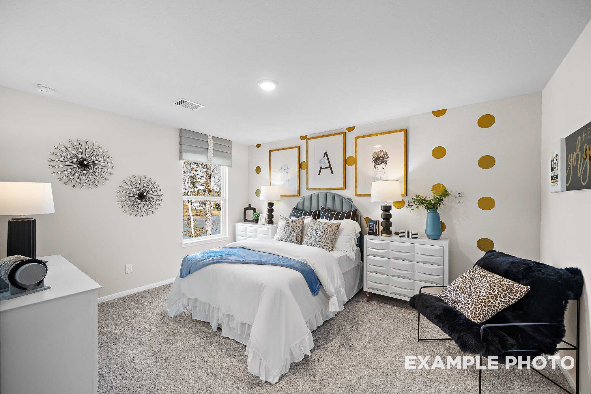 Cozy secondary bedroom in The San Marcos B by Davidson Homes, San Antonio, featuring polka dot walls, white bed with blue accents, and modern decor