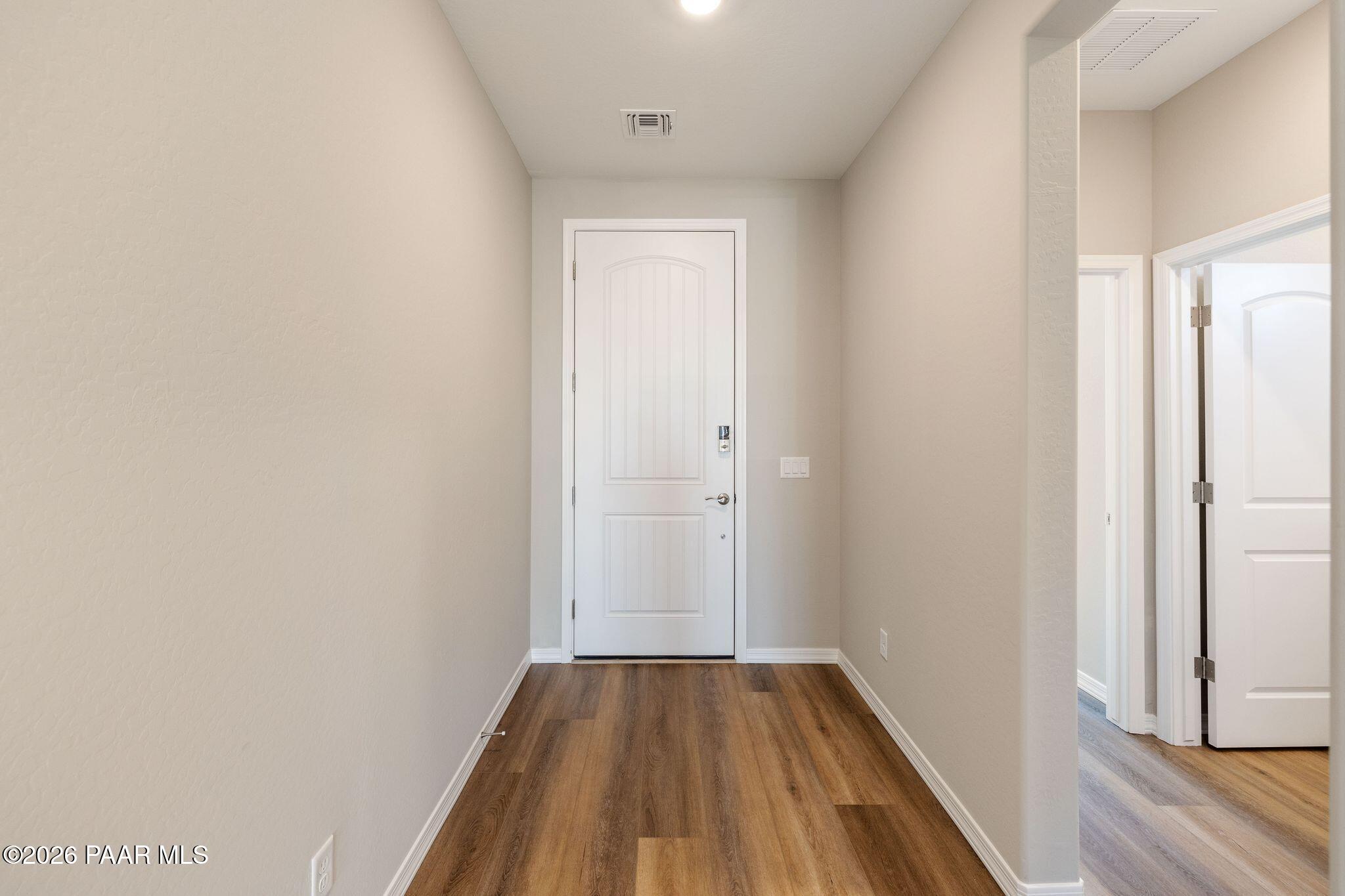 Spacious hallway with white doors, beige walls, and hardwood-look floors in Davidson Homes The Frontier A, Prescott Valley, AZ