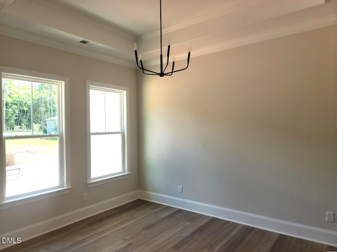 Bright dining room with hardwood floors, black chandelier, and double windows in Davidson Homes The Magnolia II B, Wake Forest, NC
