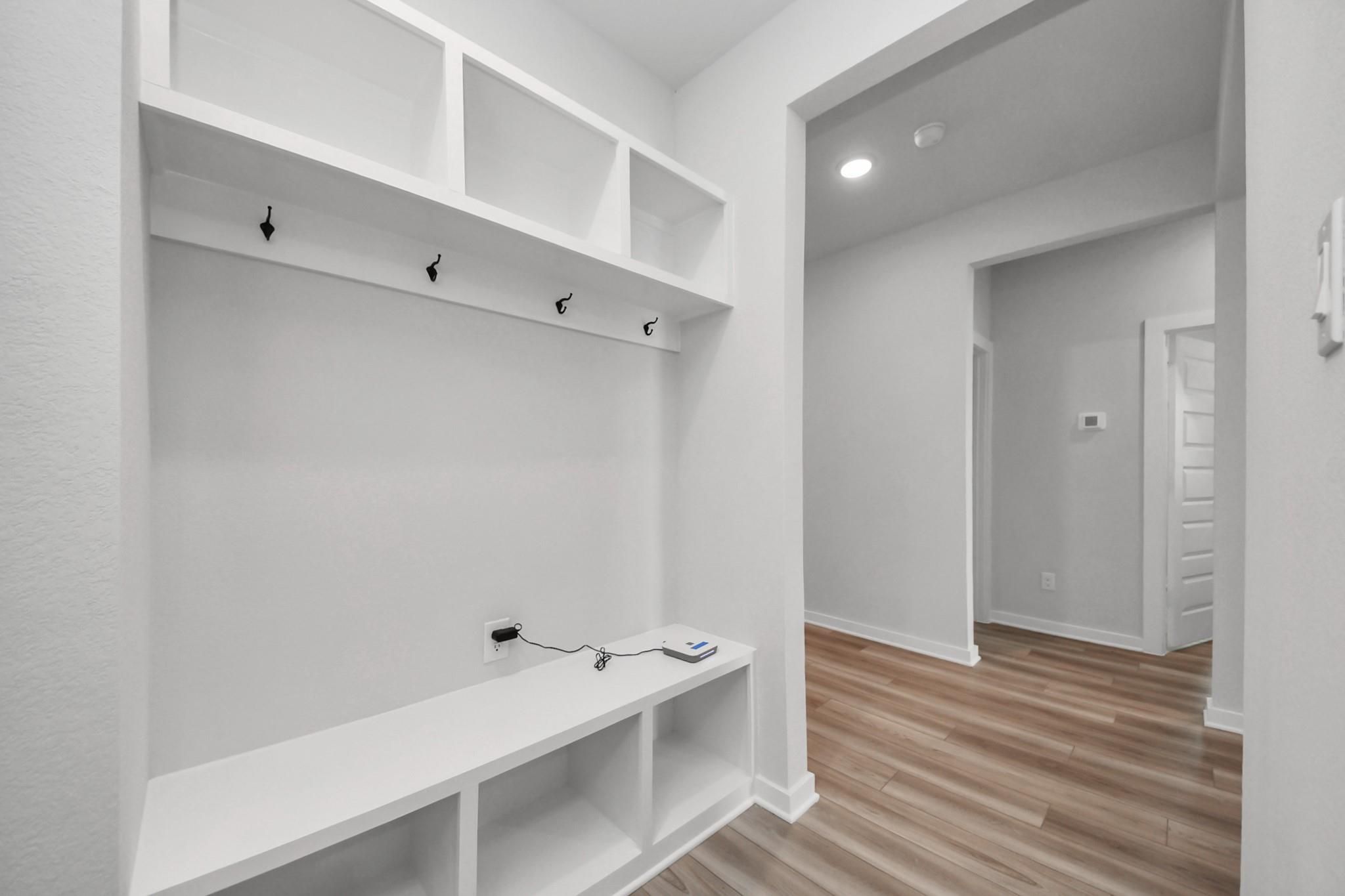 Built-in mudroom bench with coat hooks and storage cubbies in The Everett C floor plan at River Ranch Meadows, Dayton, TX.