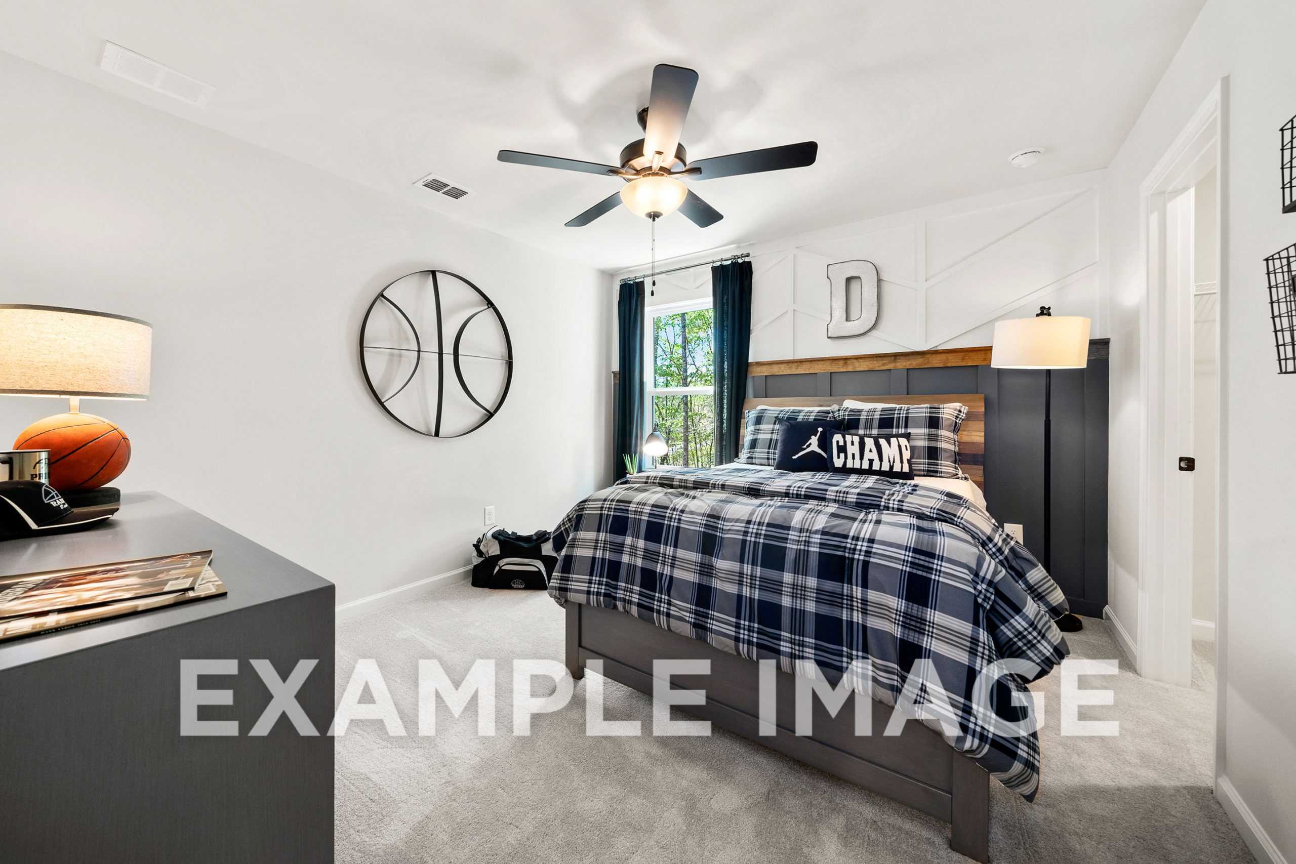 Spacious boy's bedroom in The Hickory A with basketball hoop, plaid bedding, CHAMP pillow, and ceiling fan
