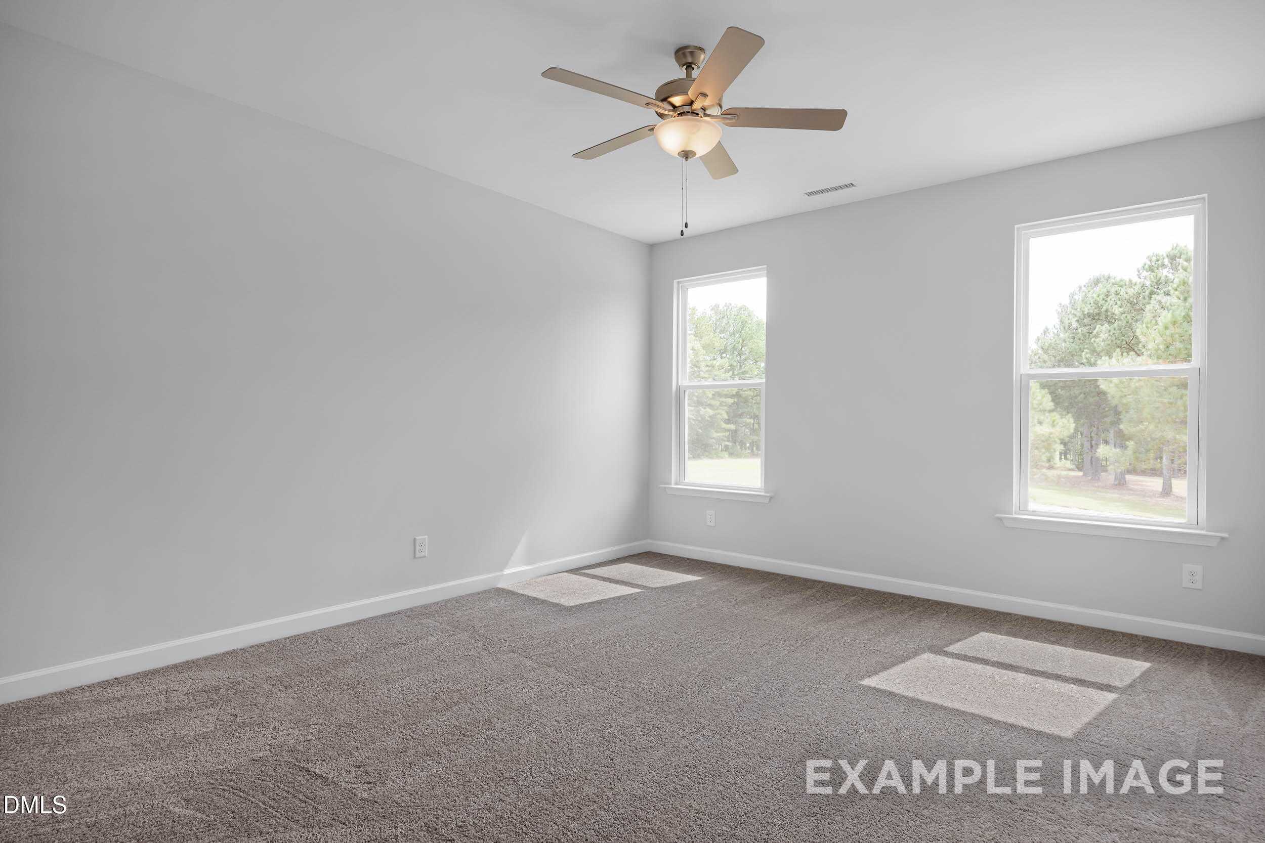 Bright bedroom with ceiling fan, beige carpet, and double windows in The Ash B floor plan, Davidson Homes, Lillington, NC