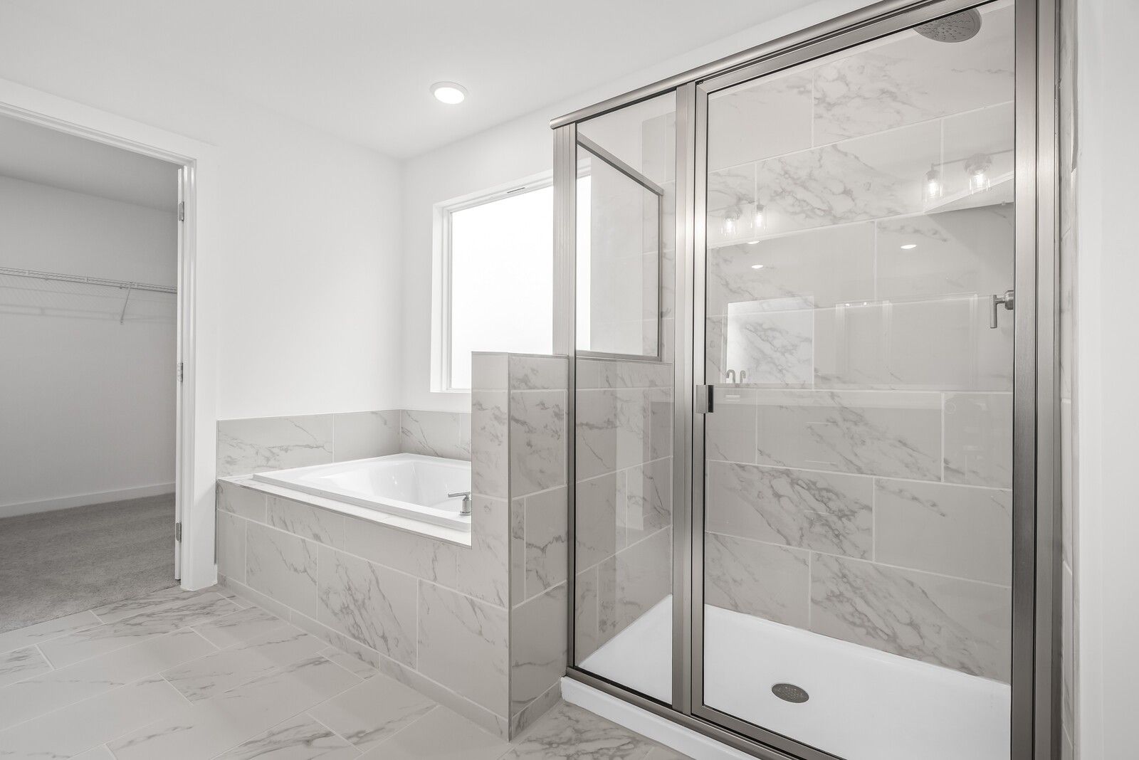 Elegant master bathroom with marble-tiled frameless shower, soaking tub in Davidson Homes The Gordon C, White House, TN
