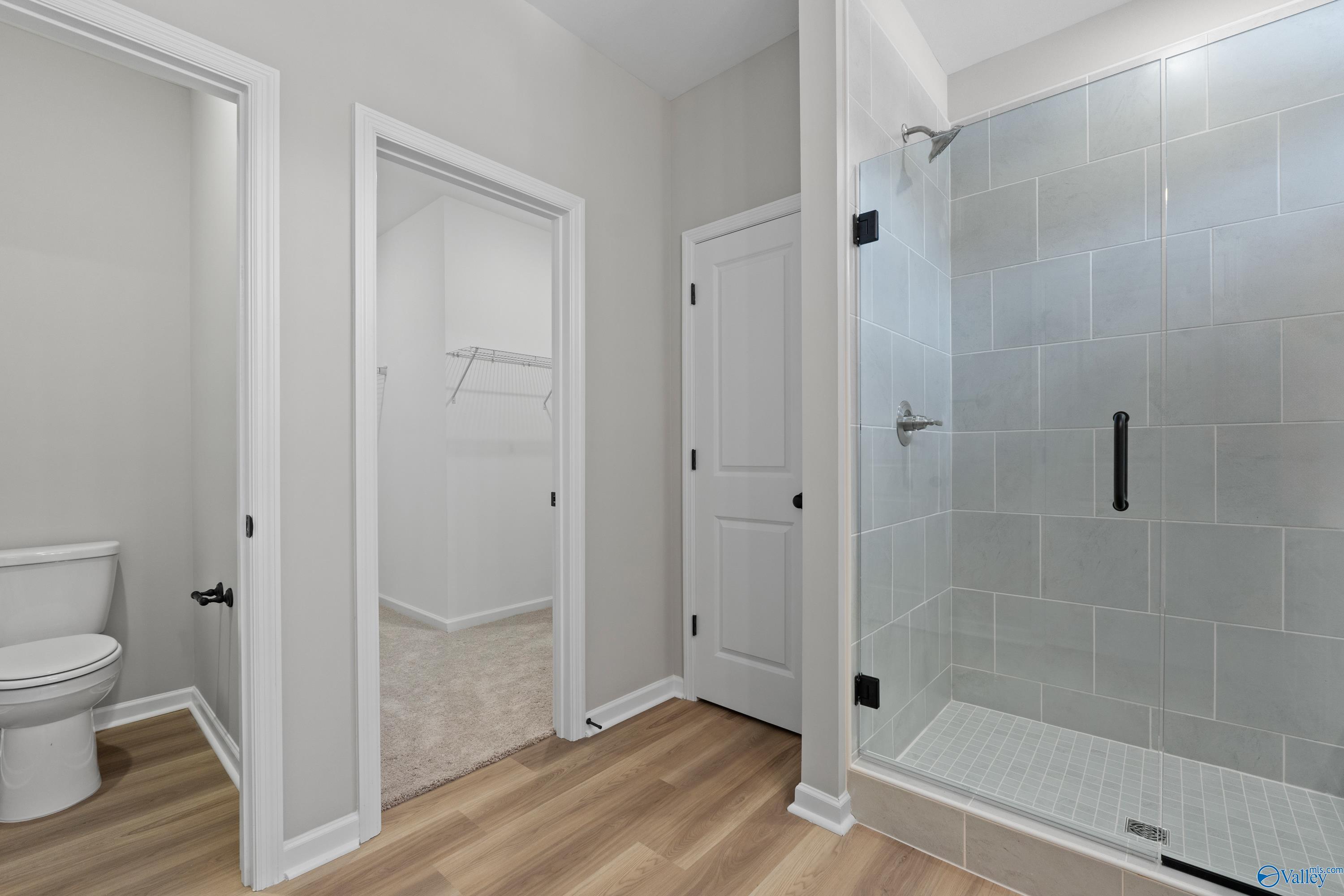 Modern master bath with frameless glass shower, subway tile, and walk-in closet in Davidson Homes The Phoenix, Fayetteville