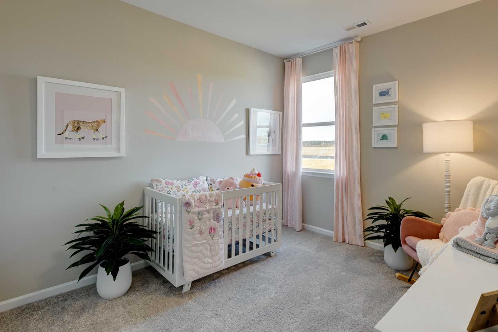 Charming nursery in The Aurora B by Davidson Homes with pink floral crib, stuffed elephant, tiger wall art, and potted plants