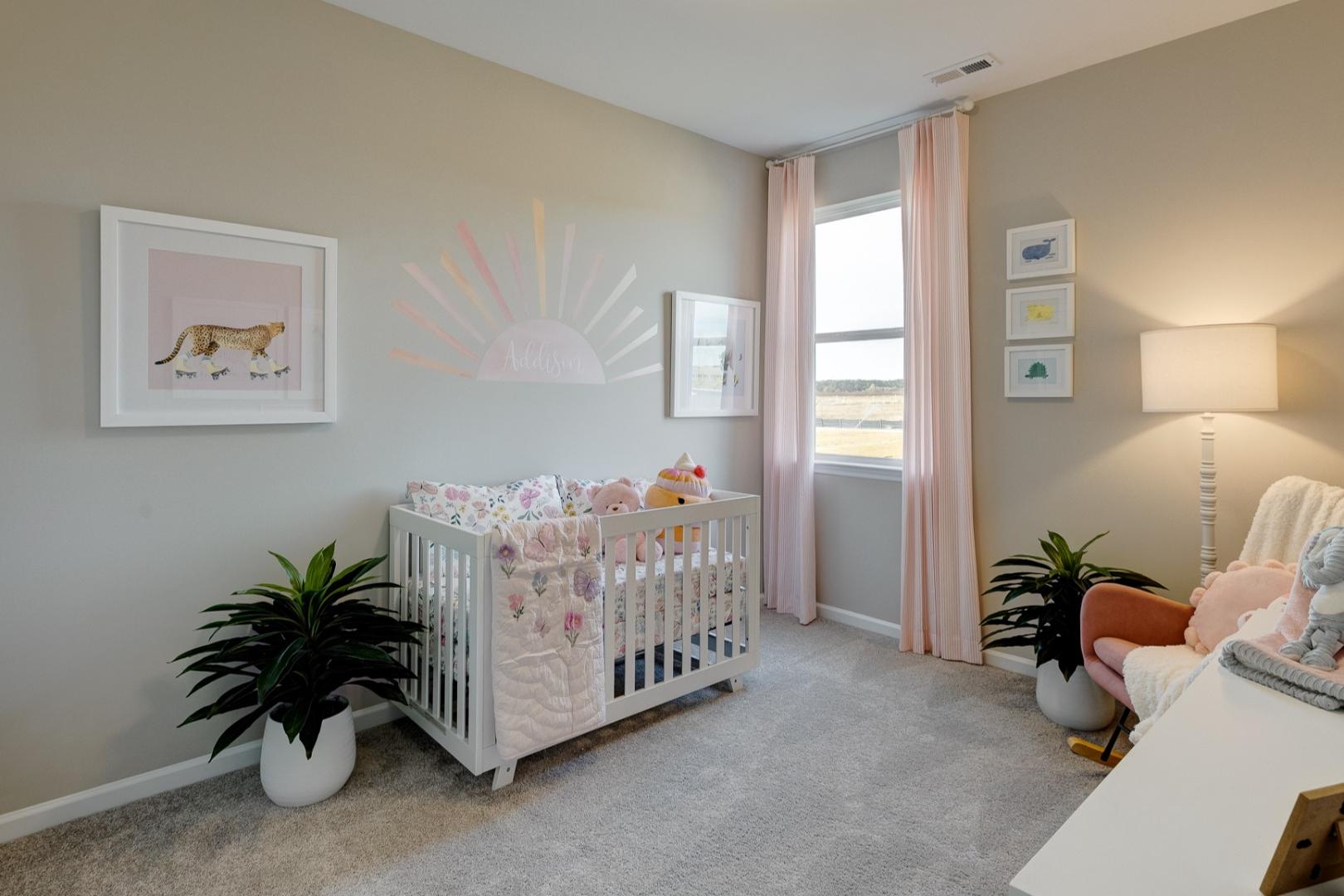 Cozy nursery in The Aurora Davidson Homes design featuring white crib with floral bedding, plush elephant toy, potted plants, and beige walls