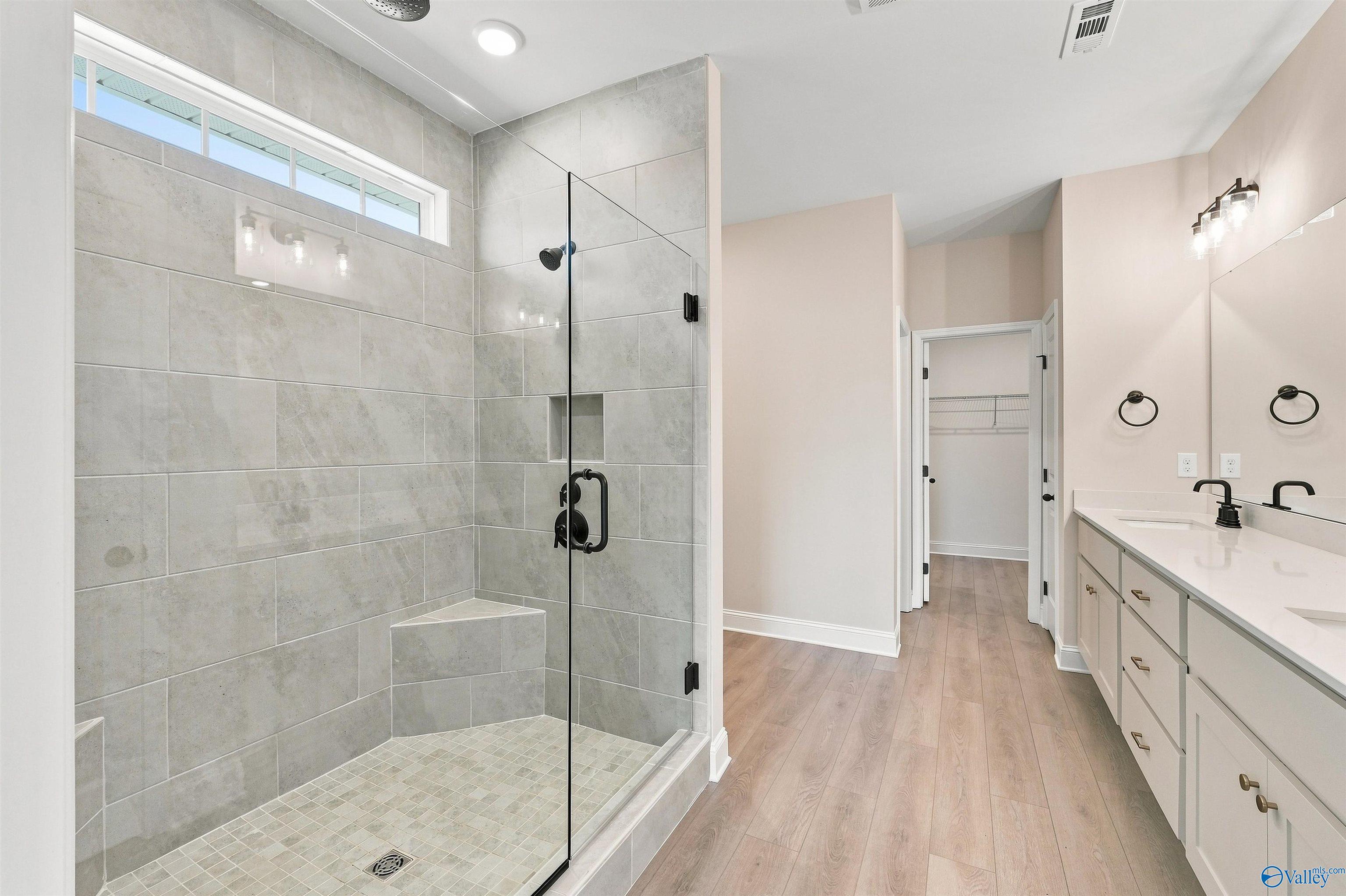 Modern master bathroom with tiled walk-in shower and dual vanity in The Oxford floor plan at Kendall Farms, Toney, Alabama.