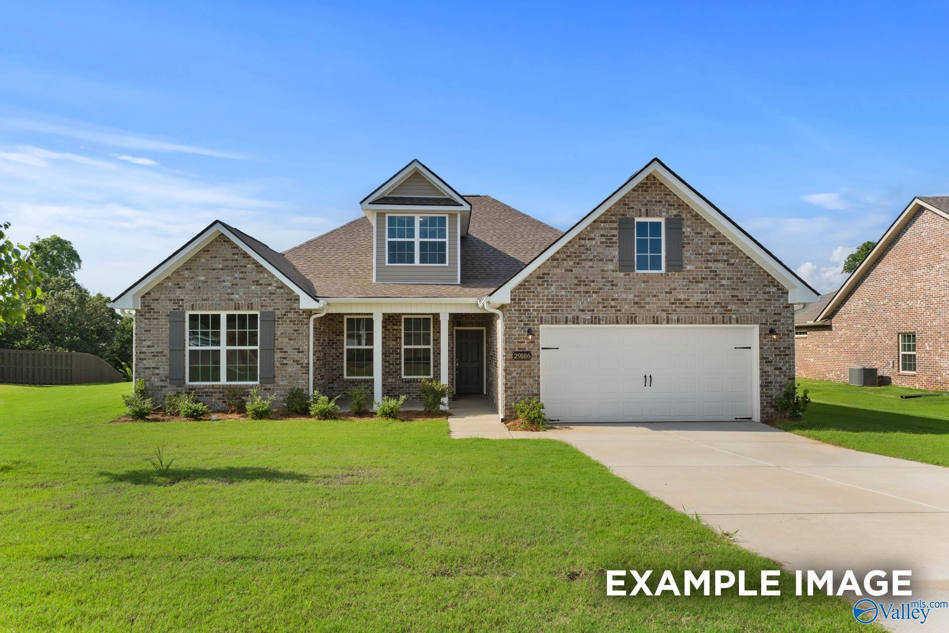 Brick 1.5-story home with gabled roof, dormer windows, 2-car garage, and landscaped yard in Madison, Alabama's Barnett's Crossing