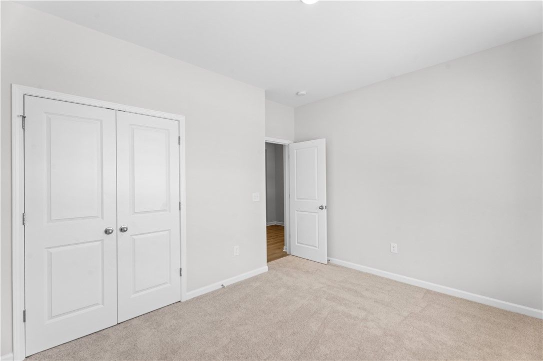 Bright secondary bedroom with double closet doors and bath access in Davidson Homes The Luna B, Opelika, Alabama