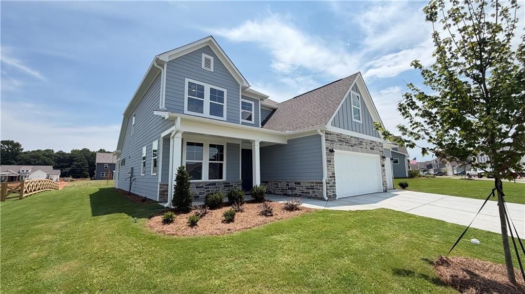 Exterior view of The Ash C floor plan by Davidson Homes featuring a 3-car garage in Wehunt Meadows, Hoschton, Georgia.