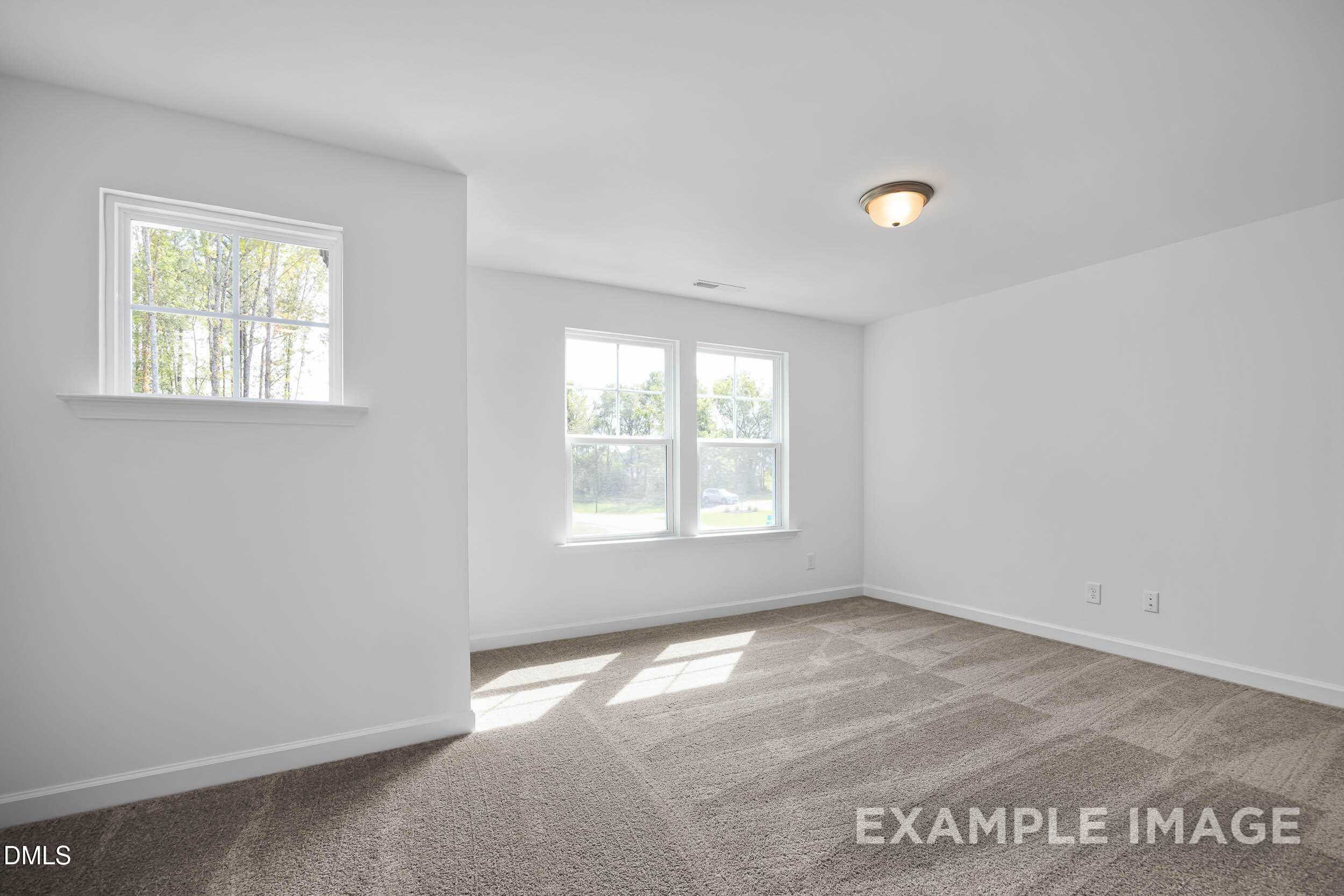 Bright secondary bedroom with large windows, natural light, and beige carpet in The Willow D by Davidson Homes, Zebulon, NC