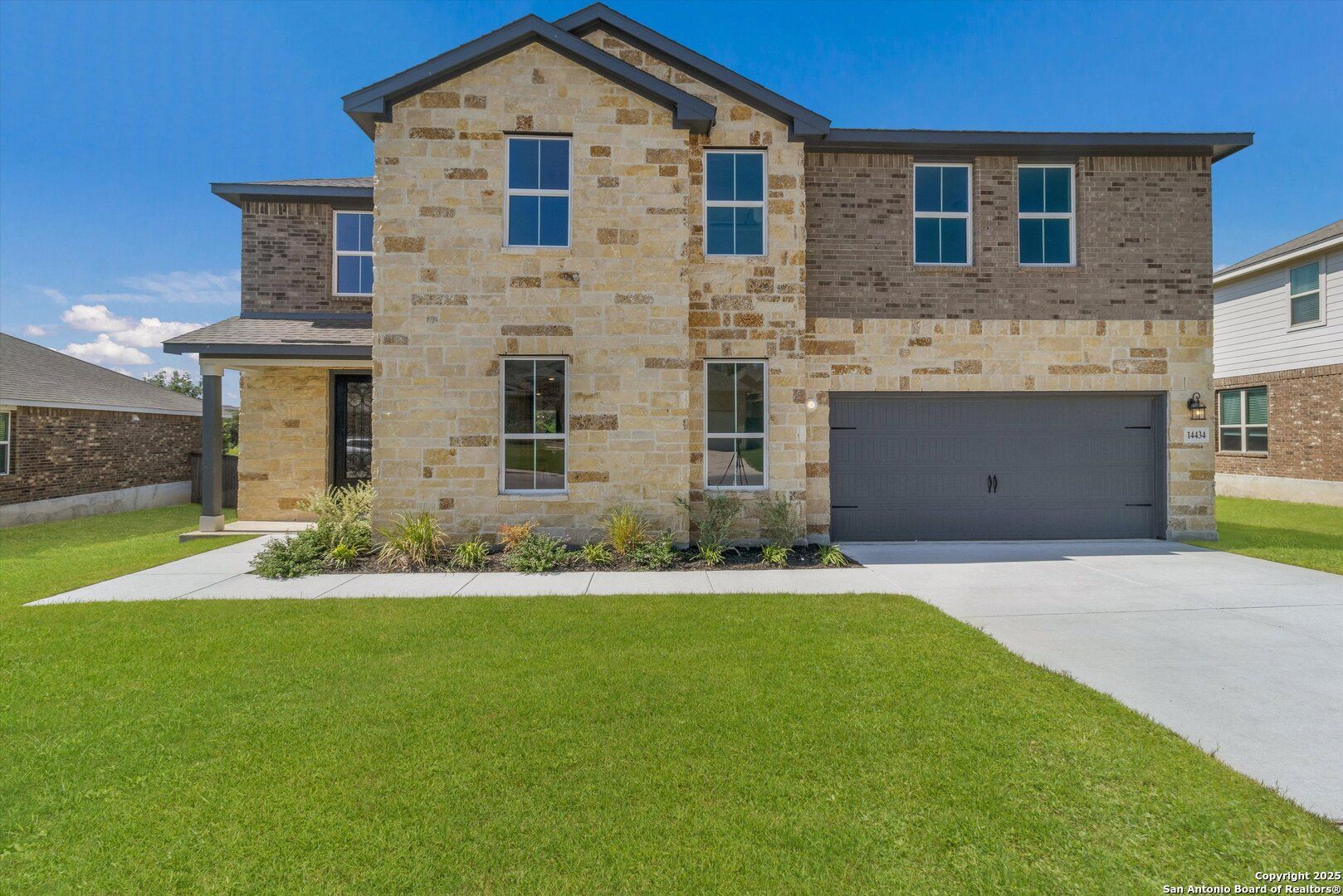 Two-story stone and brick home with 2-car garage, lush front yard in Ladera, San Antonio, Texas - Davidson Homes The Jennings H