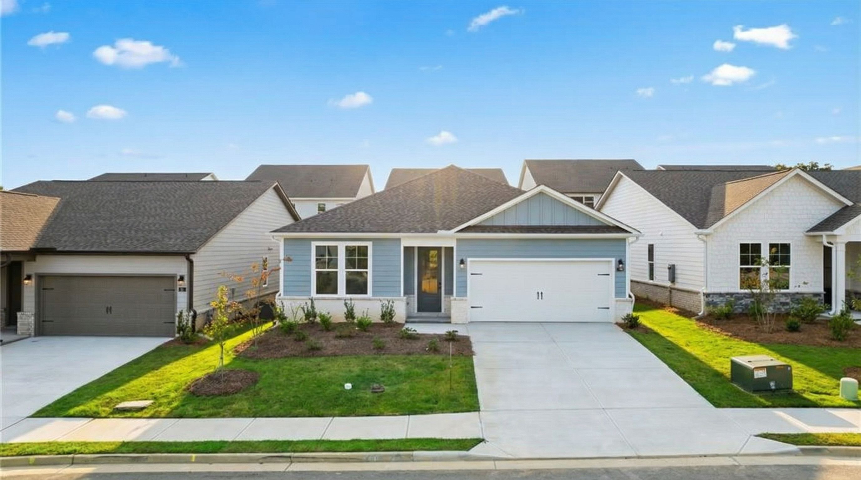 Modern single-story 3-bedroom home with 2-car garage, blue door, and landscaped yard in Kelly Preserve, Loganville, Georgia by Davidson Homes The Daphne C