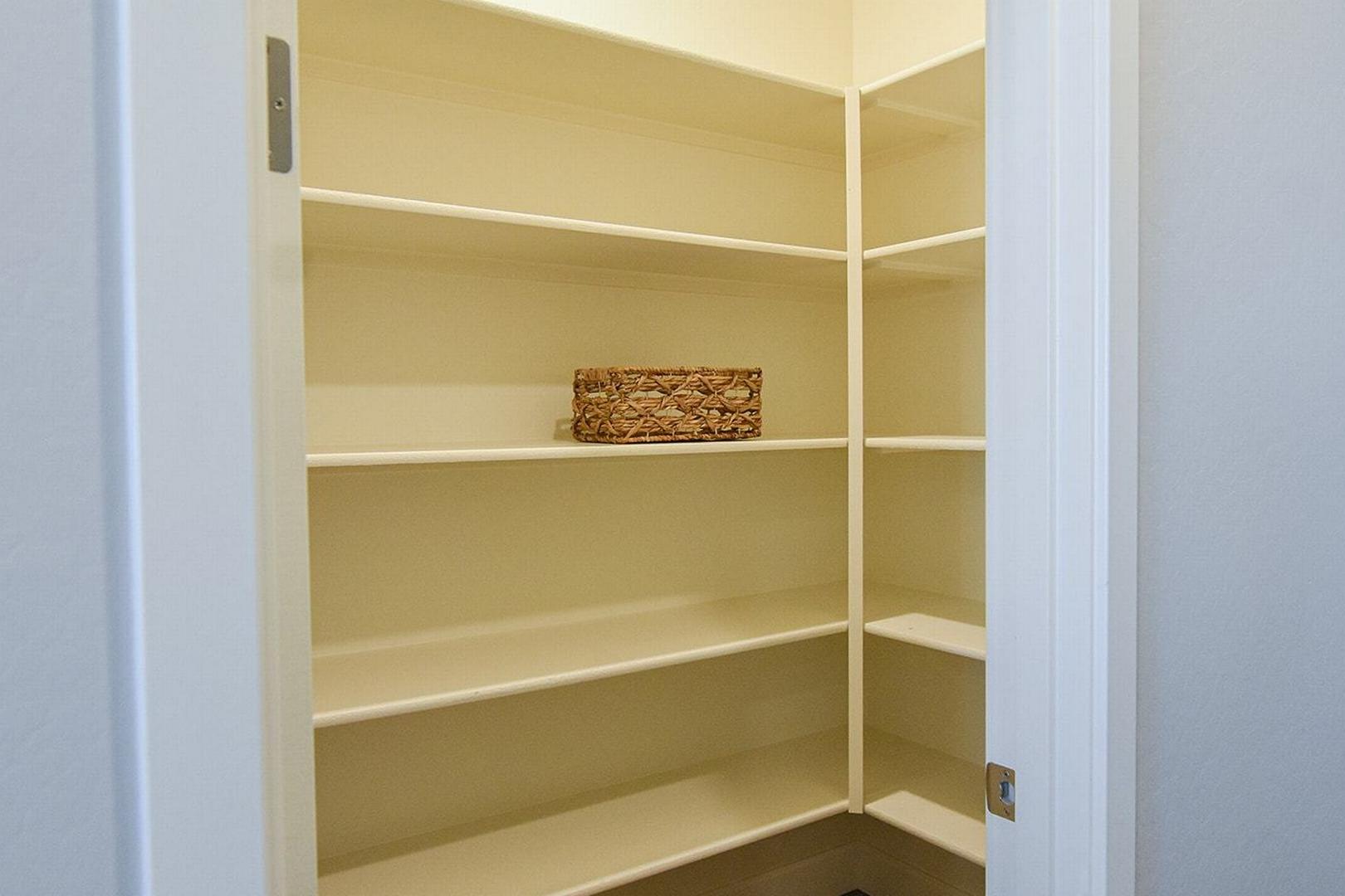 Walk-in pantry in The Summit E home with white tiered shelves and woven basket storage, Prescott Valley design