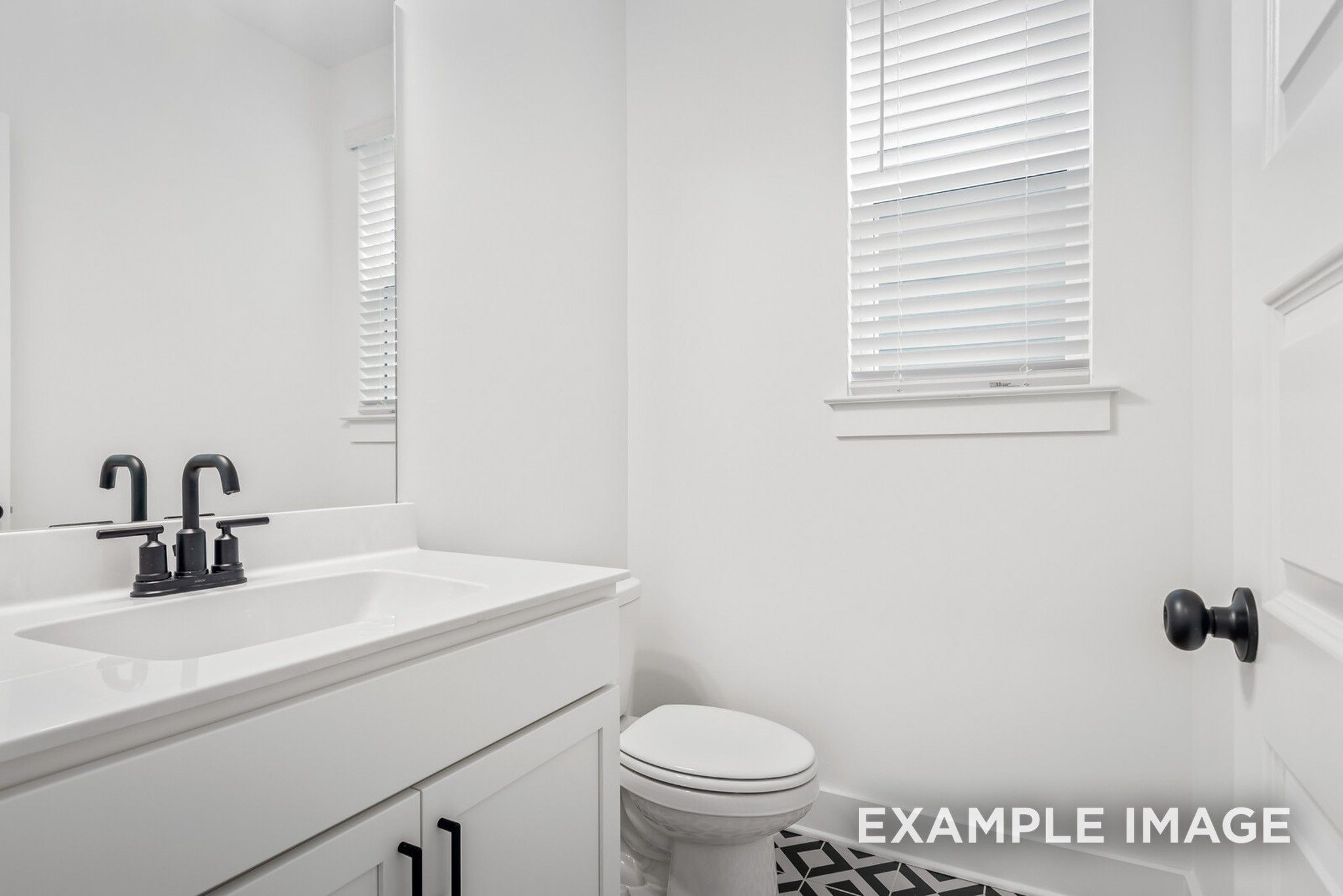Modern half bath with white vanity, black faucet, toilet, and patterned tile floor in Davidson Homes Ridgeport C, Gallatin, TN
