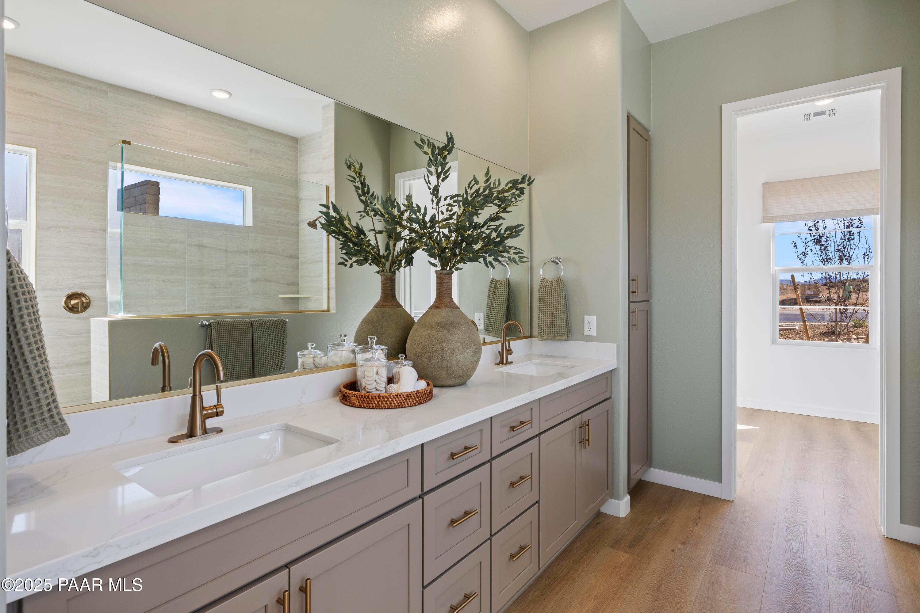 Modern master bath with double quartz vanity, gray cabinets, large mirror, and decorative plants in Davidson Homes The Blaze D, Prescott AZ