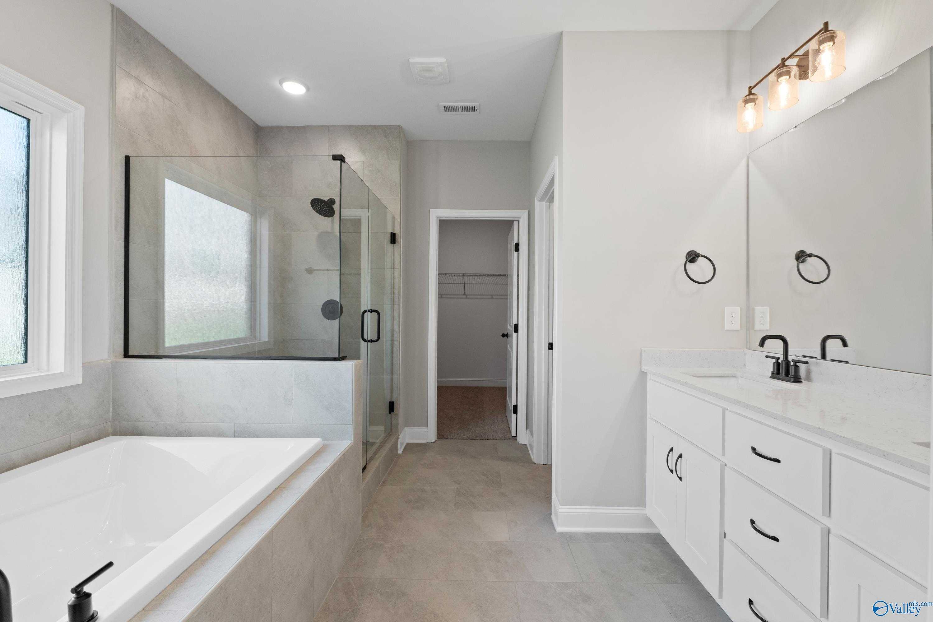 Luxurious master bathroom featuring glass shower, freestanding tub, and double vanity in Davidson Homes The Rockford with Bonus, Toney, Alabama