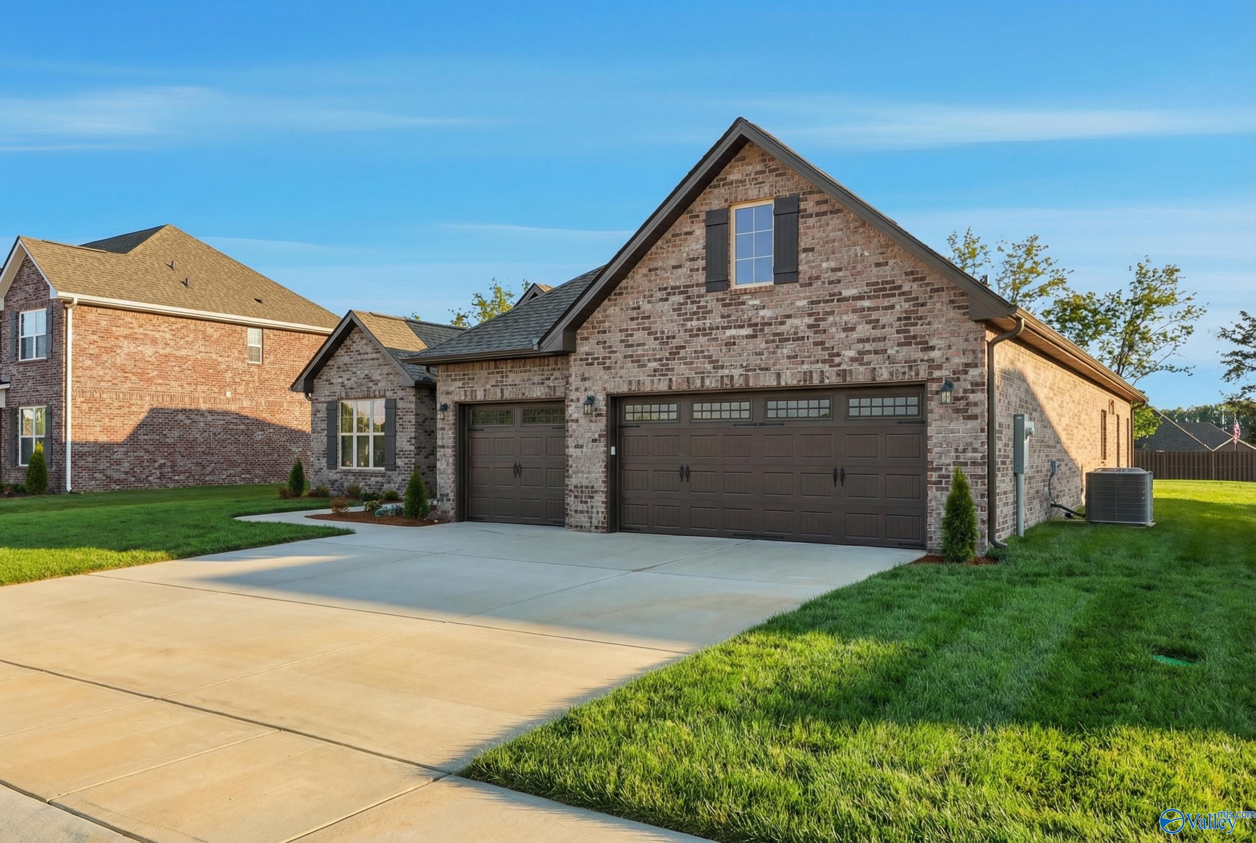 Brick 1-story home with 3-car garage, concrete driveway, and lush green lawn in Briercreek, Meridianville, Alabama by Davidson Homes The Finleigh