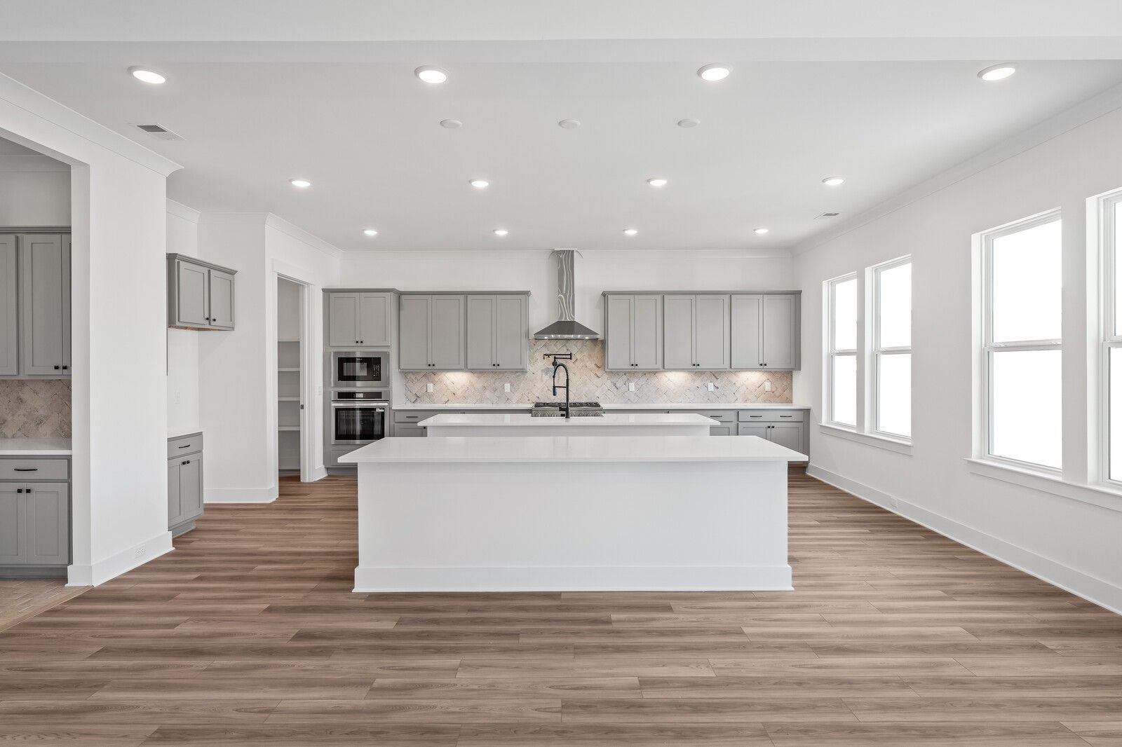 Modern kitchen featuring gray shaker cabinets, white quartz island, stainless steel appliances in Davidson Homes The Alston A, Murfreesboro, TN