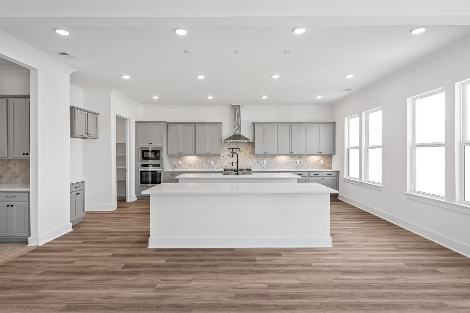 Modern kitchen featuring gray shaker cabinets, white quartz island, stainless steel appliances in Davidson Homes The Alston A, Murfreesboro, TN