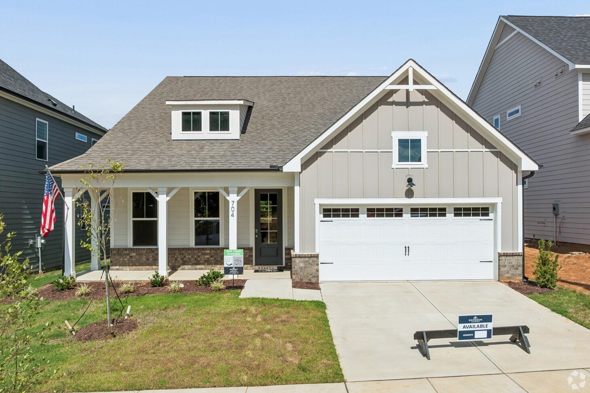 Craftsman style home exterior at Sage on North Main in Wake Forest, NC by Davidson Homes with covered porch and two-car garage