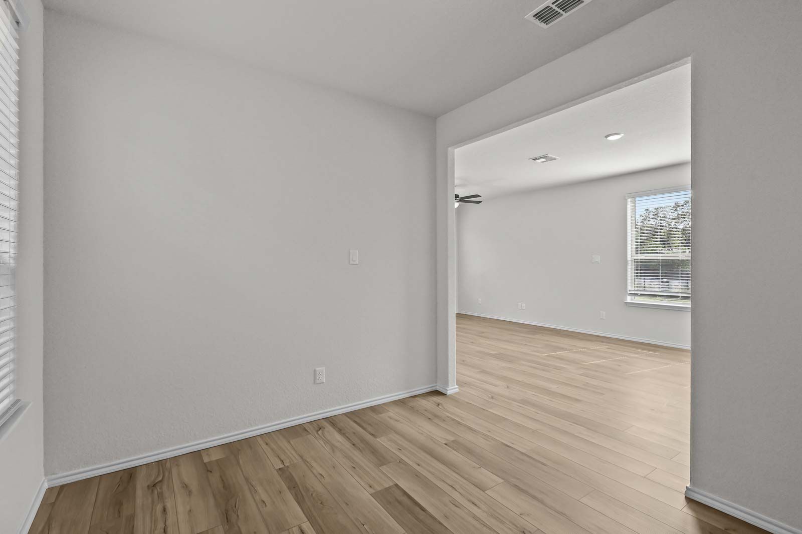 Open-concept living space in The Florence B home featuring neutral walls and light wood-style flooring in San Antonio.