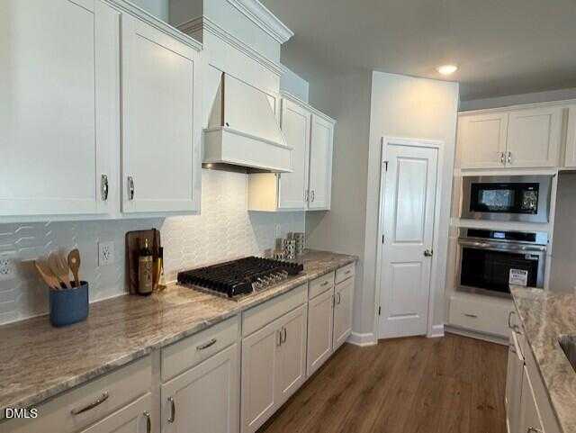 Modern kitchen with white shaker cabinets, granite counters, stainless appliances in Davidson Homes The Preston C, Lillington, NC