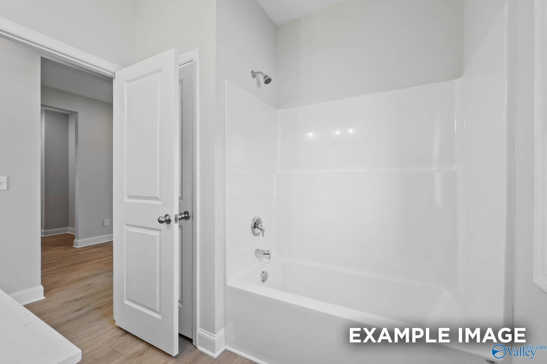 Clean white bathtub and shower combination in The Everett B floor plan home by Davidson Homes in Athens, Alabama.