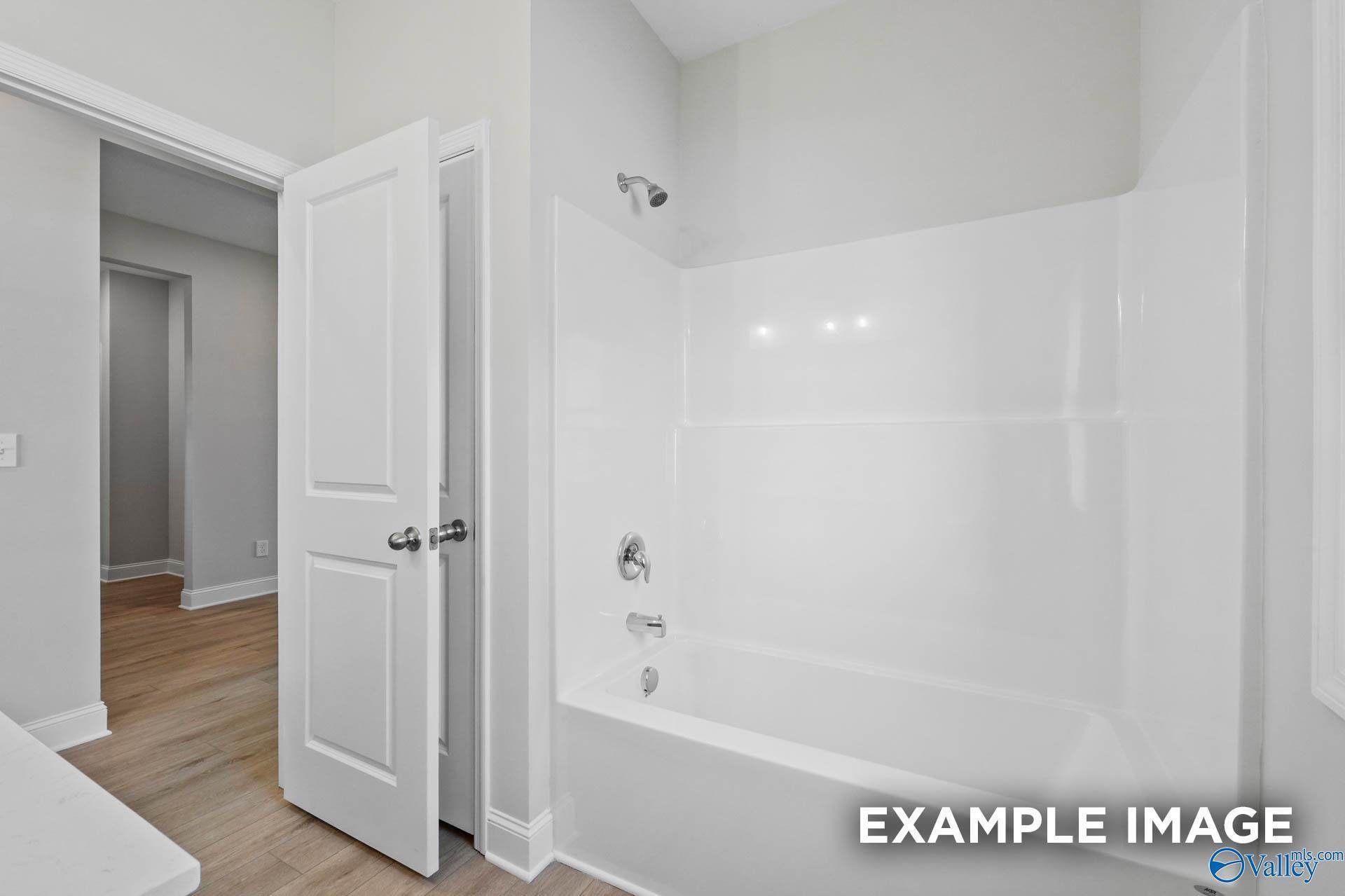 Clean white bathtub and shower combination in The Everett B floor plan home by Davidson Homes in Athens, Alabama.