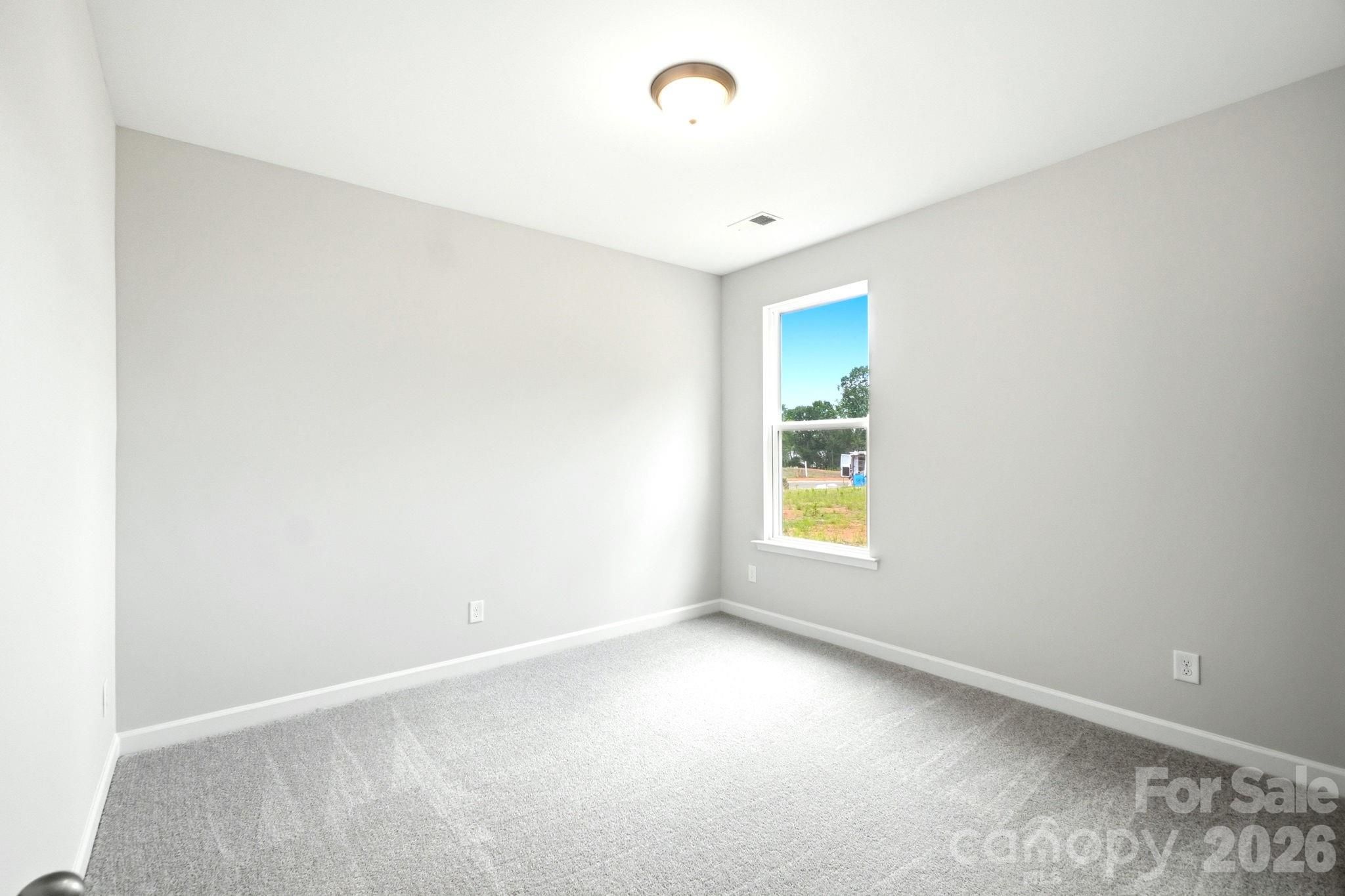 Bright, neutral-colored bedroom in The Magnolia B floor plan by Davidson Homes in Windgate, Mooresville, North Carolina.