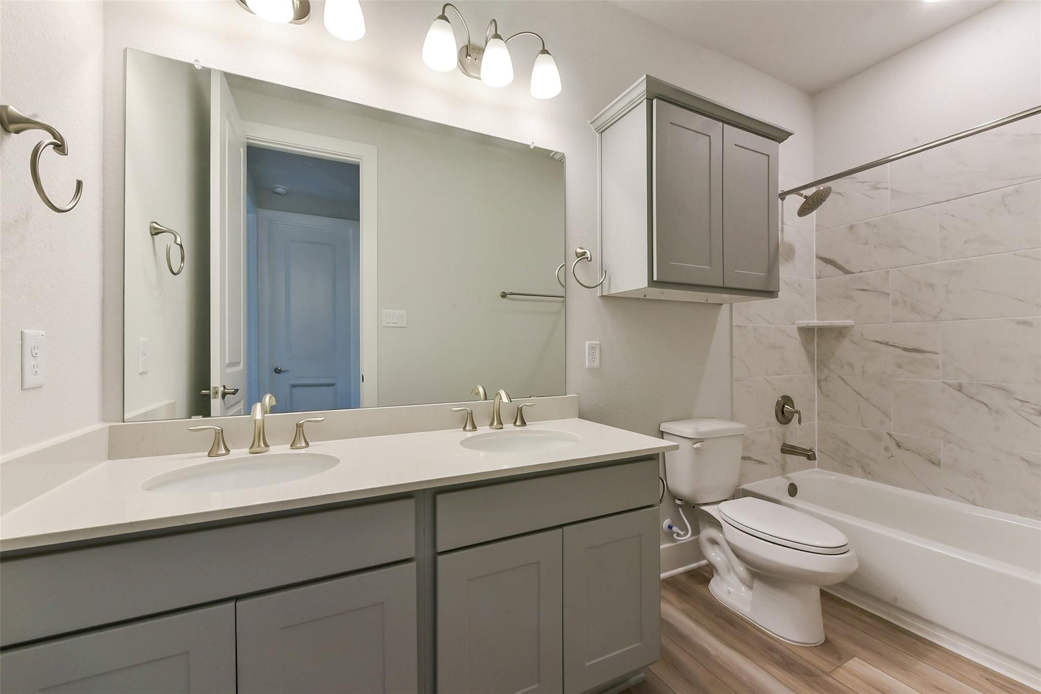 Modern master bathroom with double vanity, gray cabinets, subway tile shower, tub in Davidson Homes The Edward A, Texas City, Texas