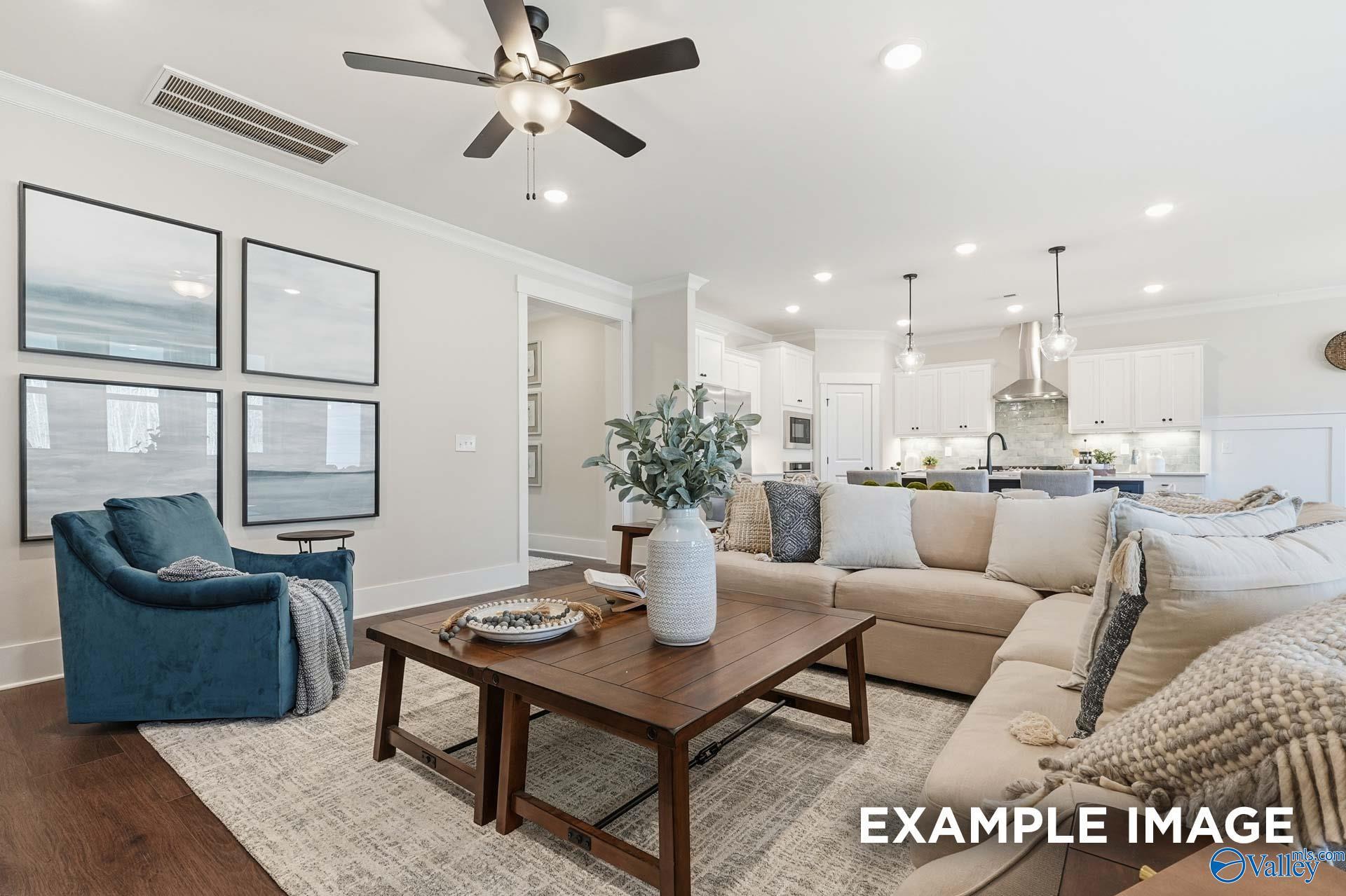 Open-concept great room with sectional sofa and white kitchen in Davidson Homes The Hibiscus F, Little Creek, Arab, Alabama