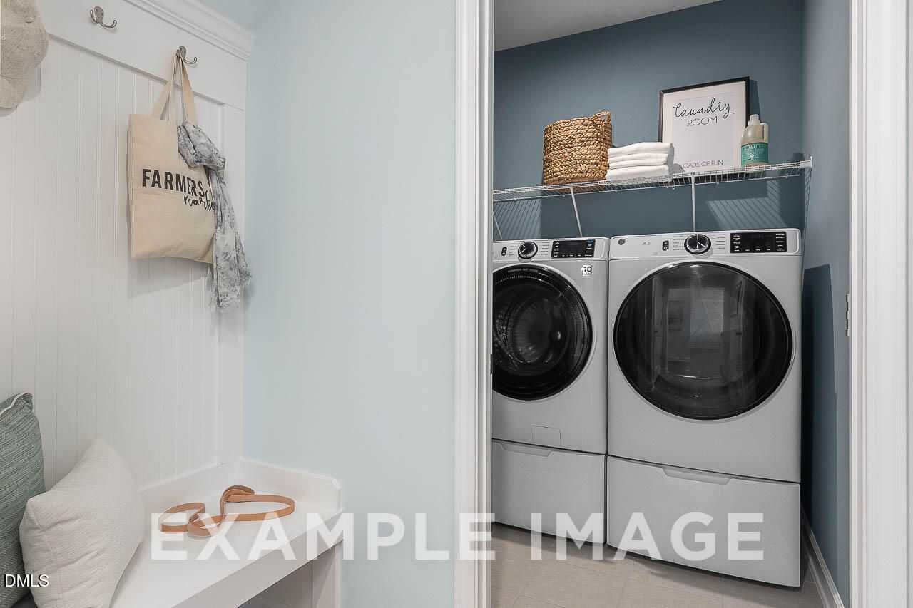 Beadboard mudroom bench and laundry room with front-load washer and dryer in Davidson Homes The Ash C, Lillington, NC