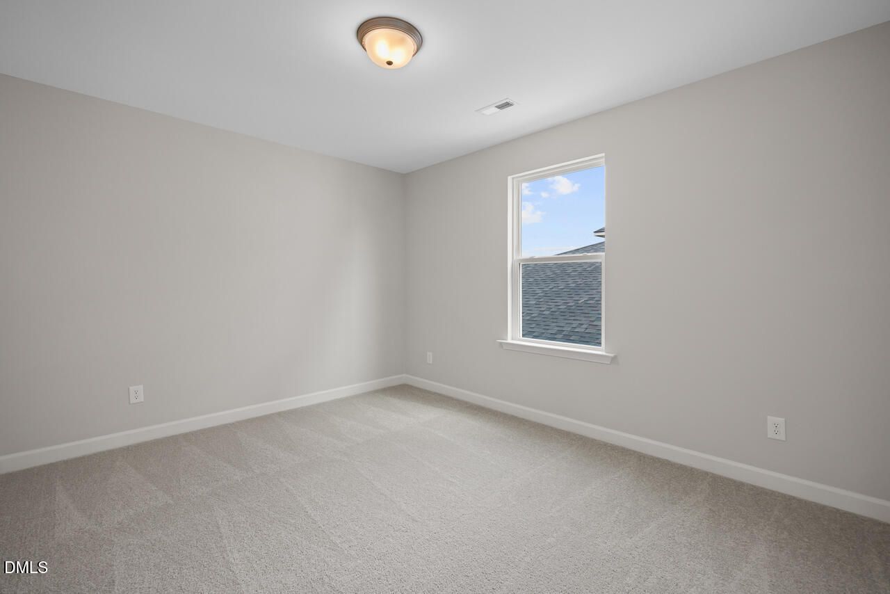 Spacious neutral-toned bedroom with plush carpet in The Chestnut floor plan at Wendell Ridge, Wendell, North Carolina.
