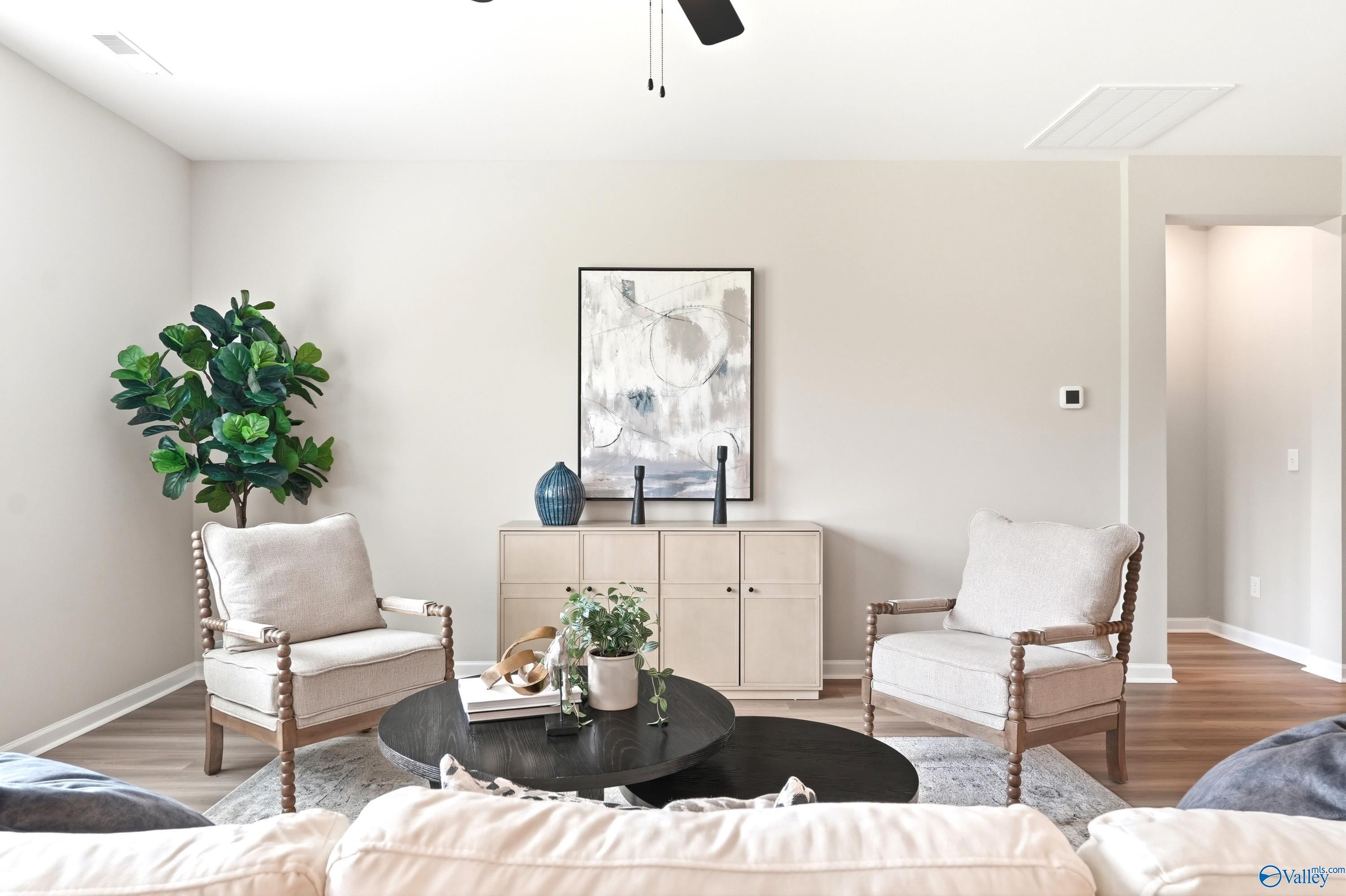 Modern living room with neutral decor, twin accent chairs, and coffee table in The Dorado floor plan, Riverton Preserve.