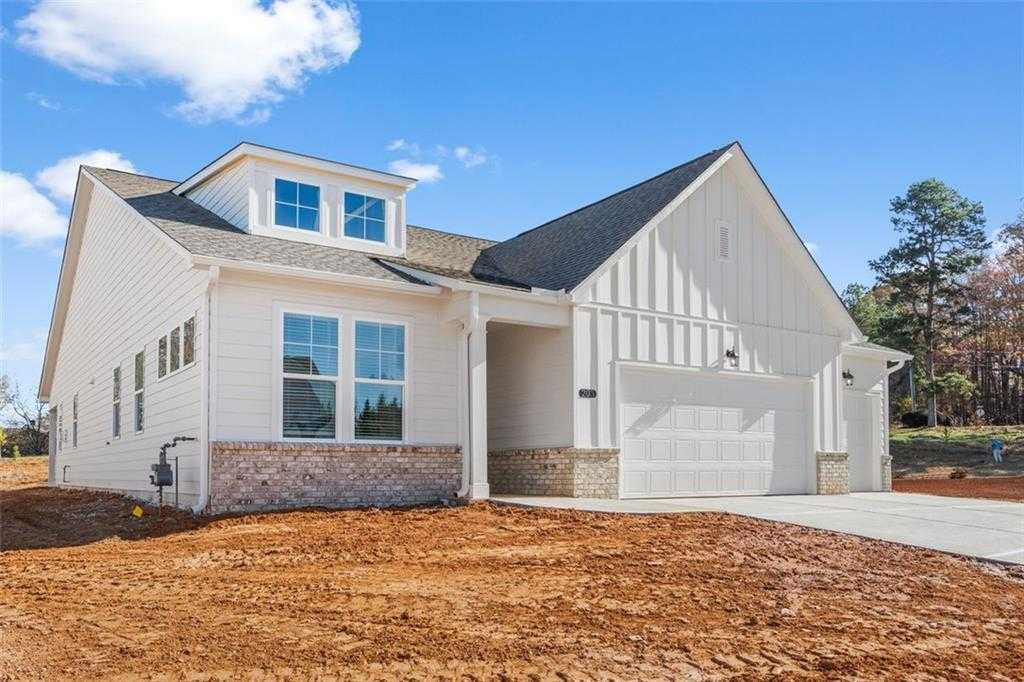 White single-story The Glenwood C home with 3-car garage, board-and-batten siding, and brick accents in Wehunt Meadows, Hoschton, Georgia