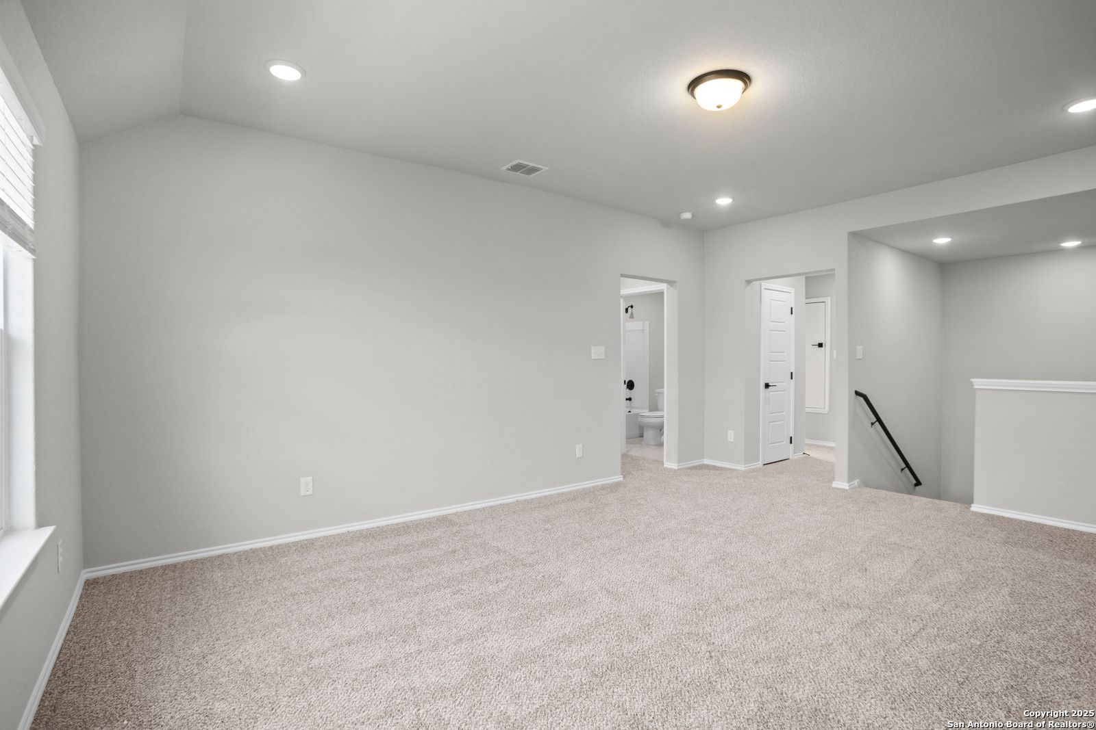 Spacious upstairs hallway with beige carpet, recessed lights, and adjacent bathroom in Davidson Homes The Sequoia A, Converse, Texas