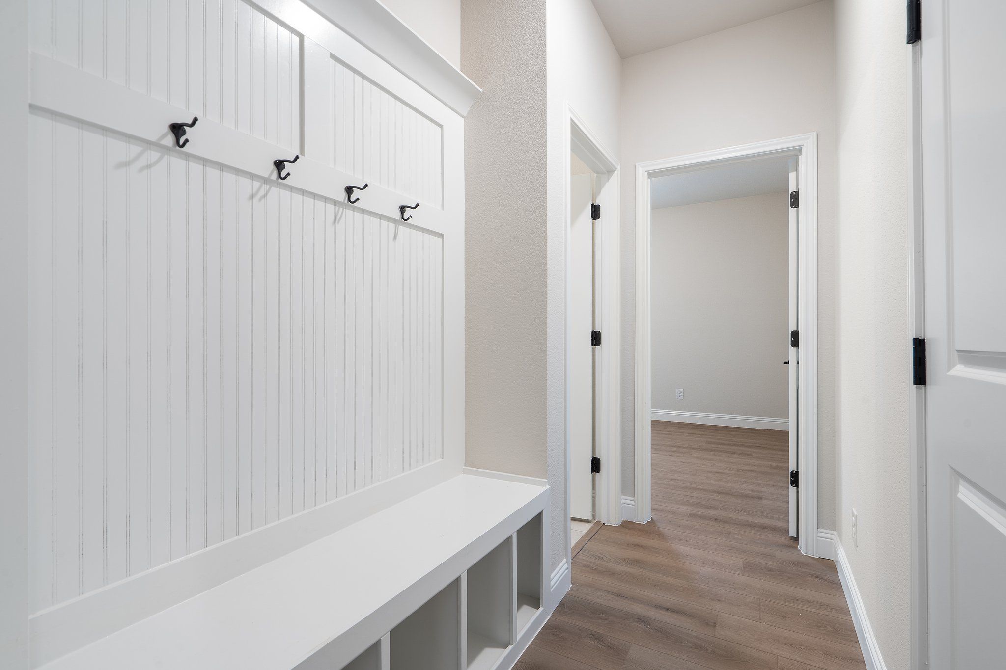 Built-in mudroom bench with coat hooks in the hallway of The Holly F floor plan by Davidson Homes.