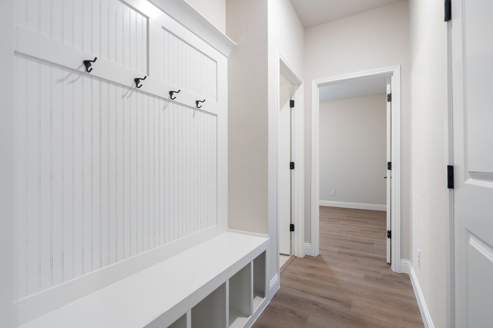 Built-in mudroom bench with coat hooks in the hallway of The Holly F floor plan by Davidson Homes.