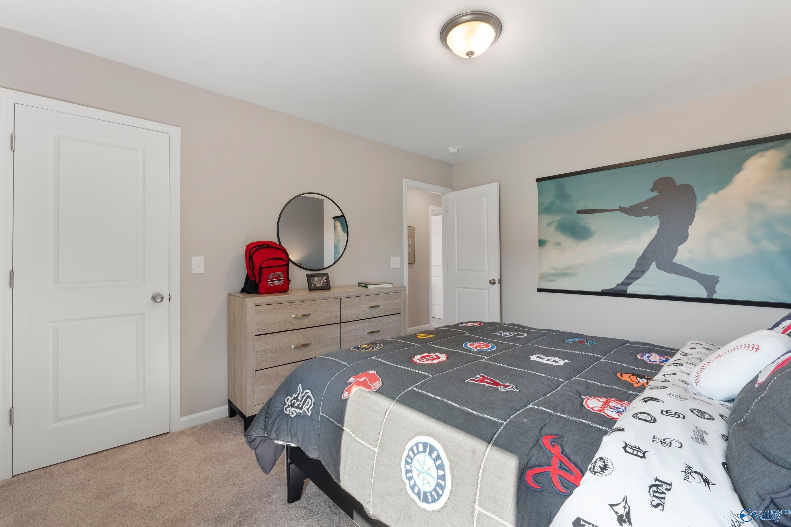 Baseball-themed child's bedroom with MLB comforter, dresser, mirror, red backpack in The Stella 3-bedroom home, Madison, Alabama