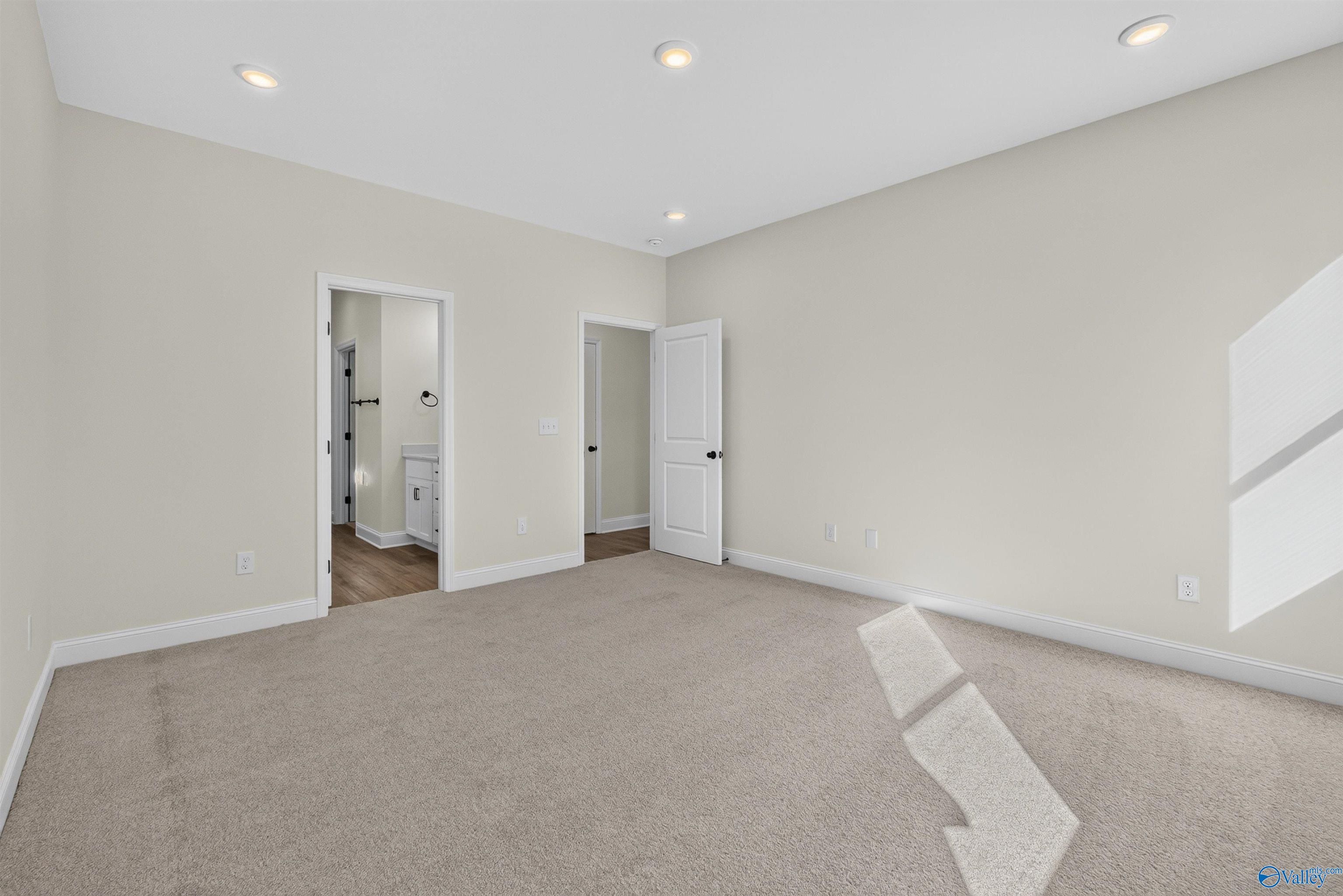 Spacious carpeted bedroom with recessed lighting and en suite bath access in Davidson Homes Ashport L plan, Berry Cove, New Market, AL