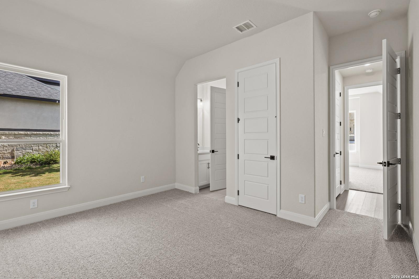 Spacious bedroom with en-suite bathroom in The Summerlin B floor plan by Davidson Homes in Potranco Oaks, Castroville, Texas.