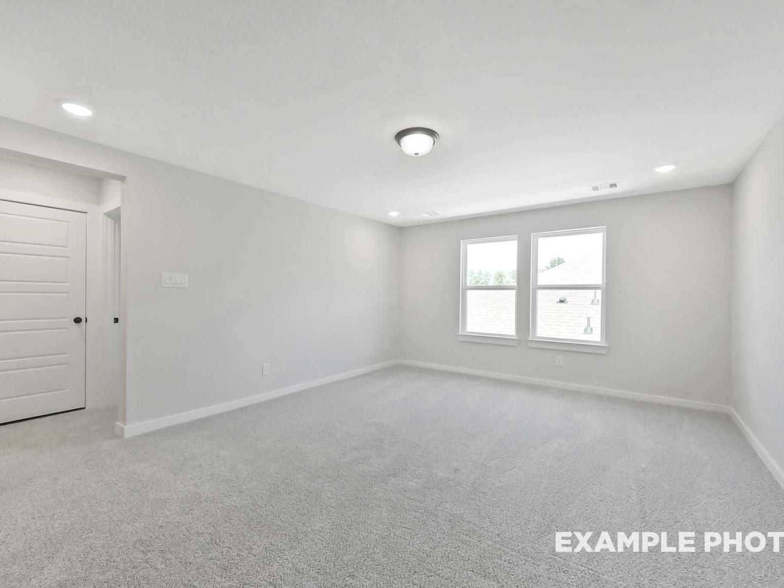 Spacious, carpeted bedroom with neutral walls and natural light in The Sequoia C floor plan at Sundance Cove, Crosby, TX.