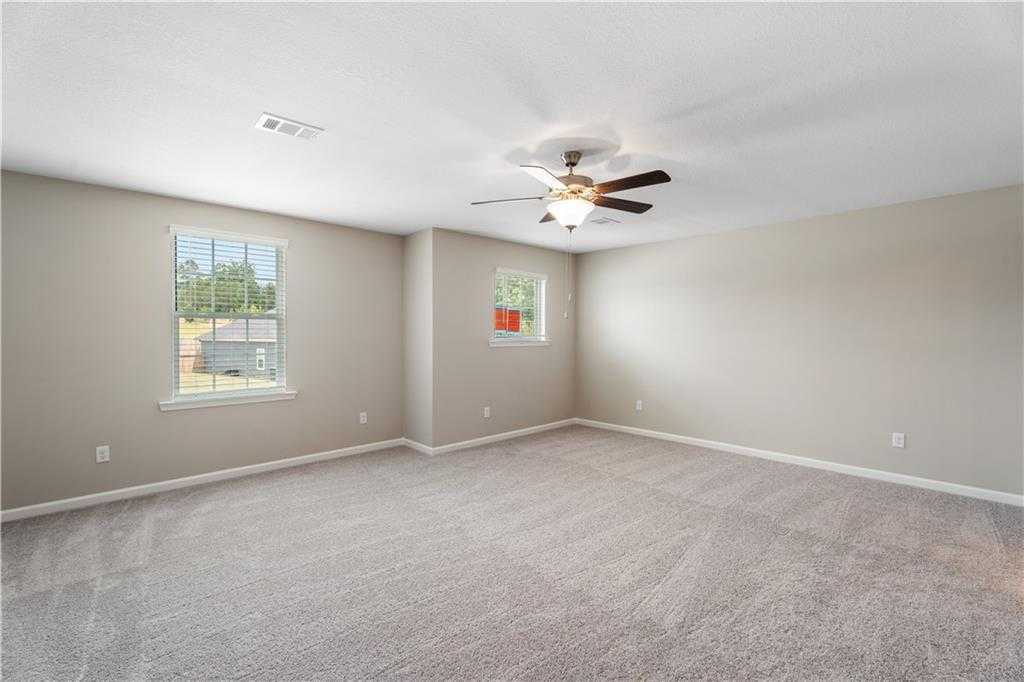 Bright secondary bedroom with ceiling fan, beige carpet, and window views in Davidson Homes The Bartlett, Phenix City, Alabama