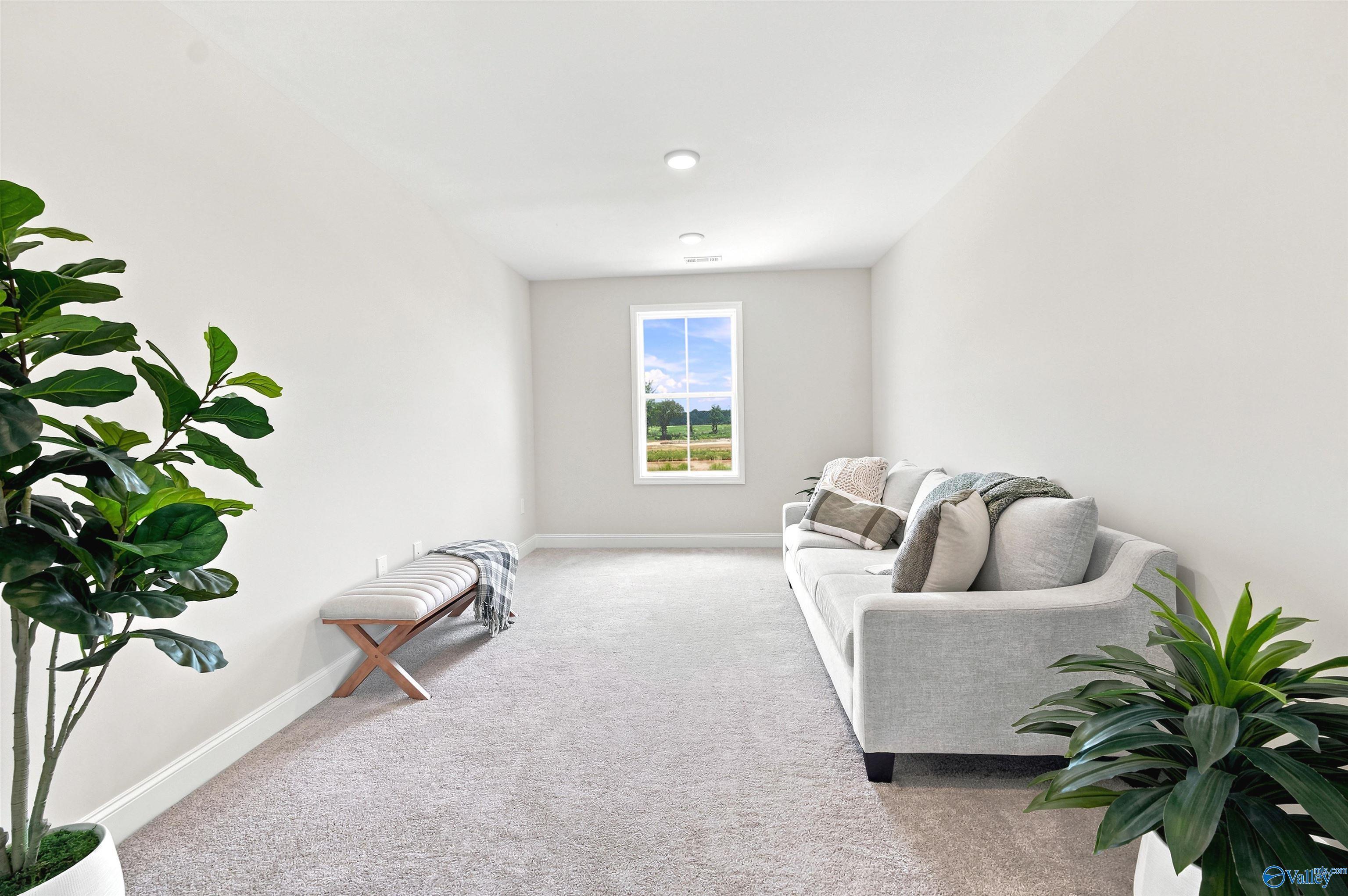 Bright upstairs loft area with plush carpet and modern decor in The Burton B floor plan at Heritage Lakes, New Market, AL.