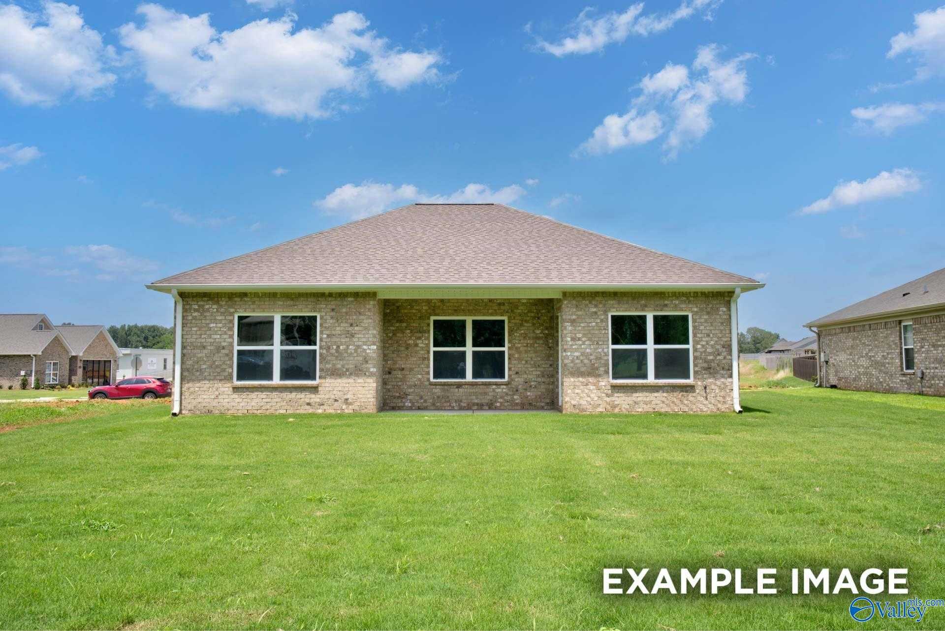 Tan brick single-story home with 2-car garage, double windows, and lush green lawn in Lynn Meadows, Meridianville, Alabama - Davidson Homes Asheville C