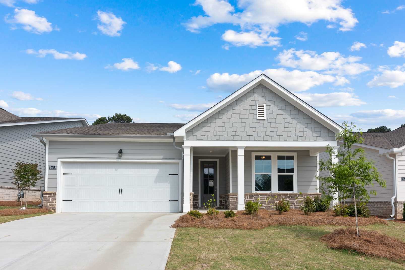 Modern craftsman exterior of The Dawson A 1-story home with gray siding, 2-car garage, and columned porch in Loganville GA