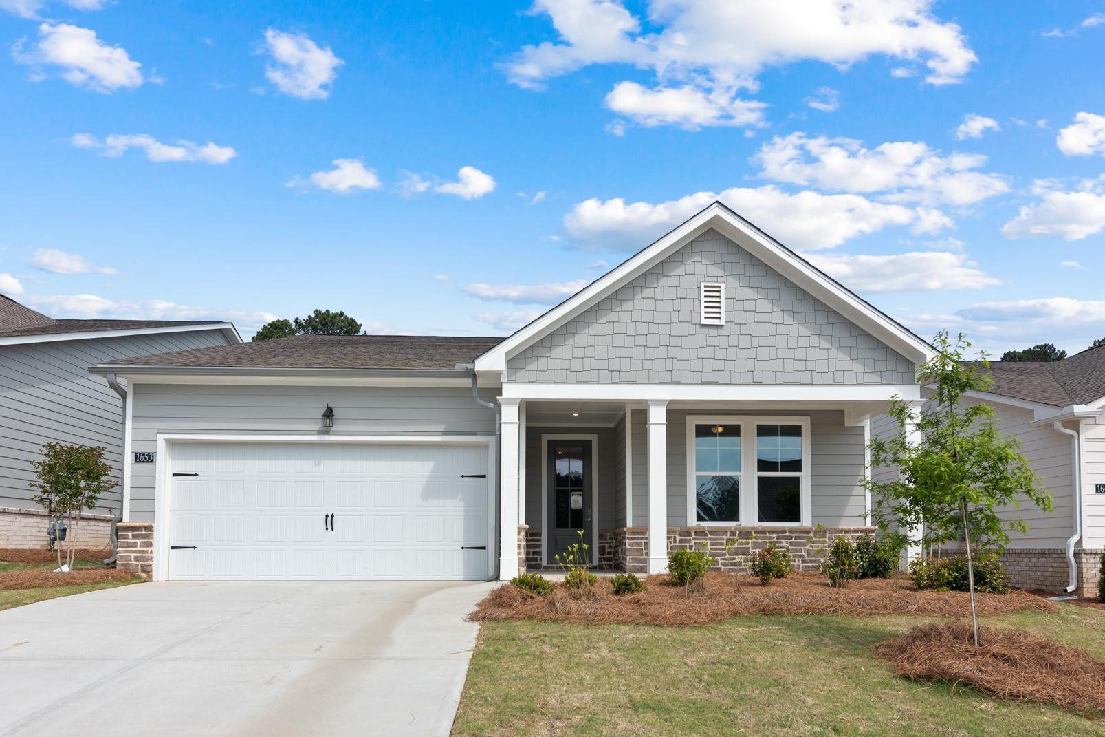 Modern craftsman exterior of The Dawson A 1-story home with gray siding, 2-car garage, and columned porch in Loganville GA