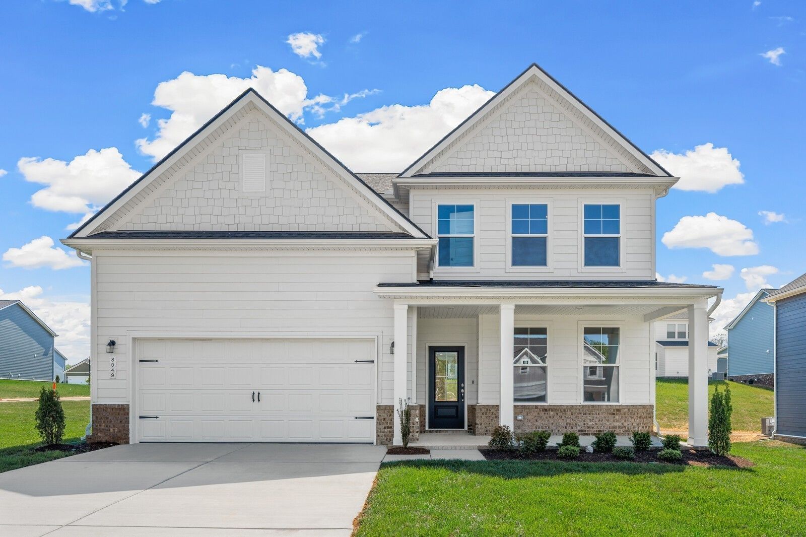 Two-story Davidson Homes Henry C floor plan with white siding, brick accents, and two-car garage in Calista Farms, Tennessee.