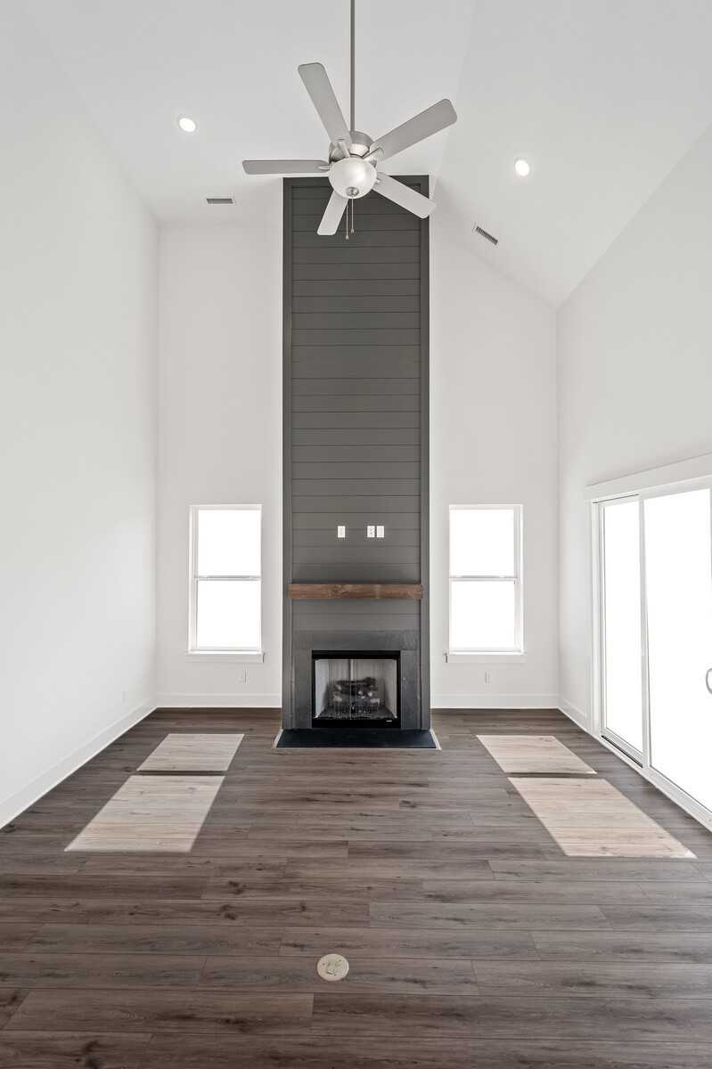 Vaulted two-story great room with stone fireplace, dual ceiling fans, hardwood floors in The Hawkins floor plan, Murfreesboro, TN